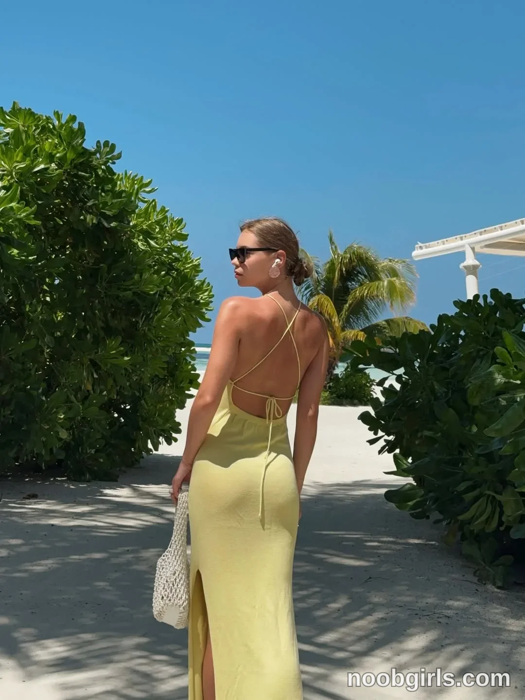 CoverM Standing with her back toward the camera