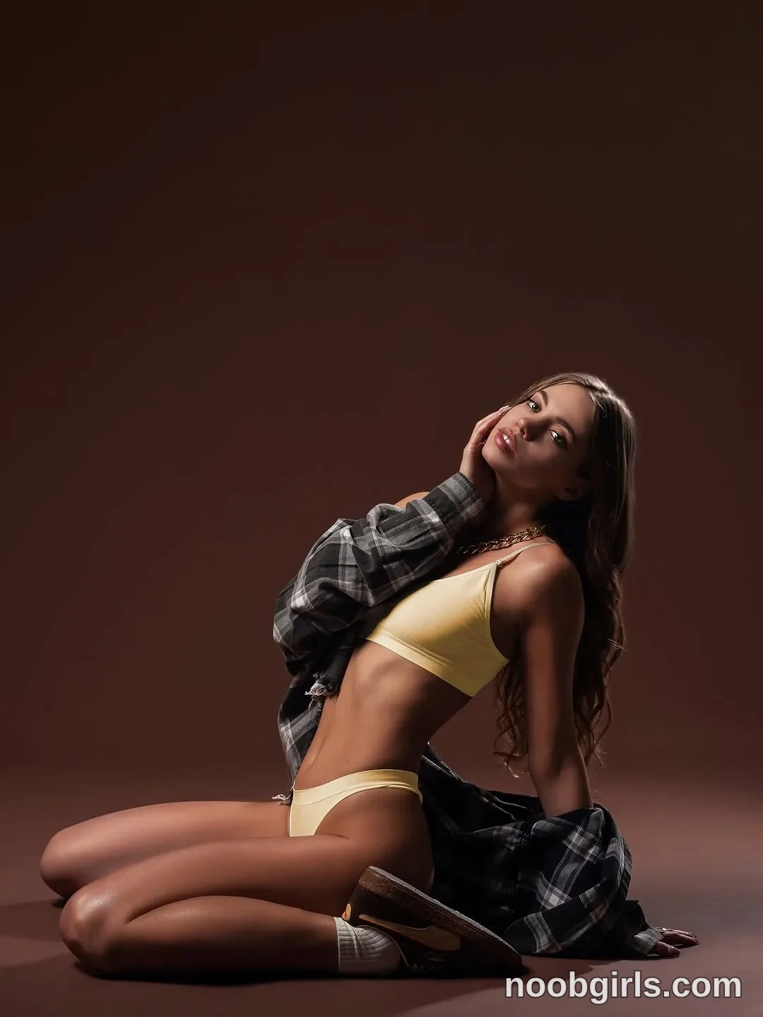 CoverM Sitting on the floor with her legs folded to one side wearing Pale yellow bra in photo studio