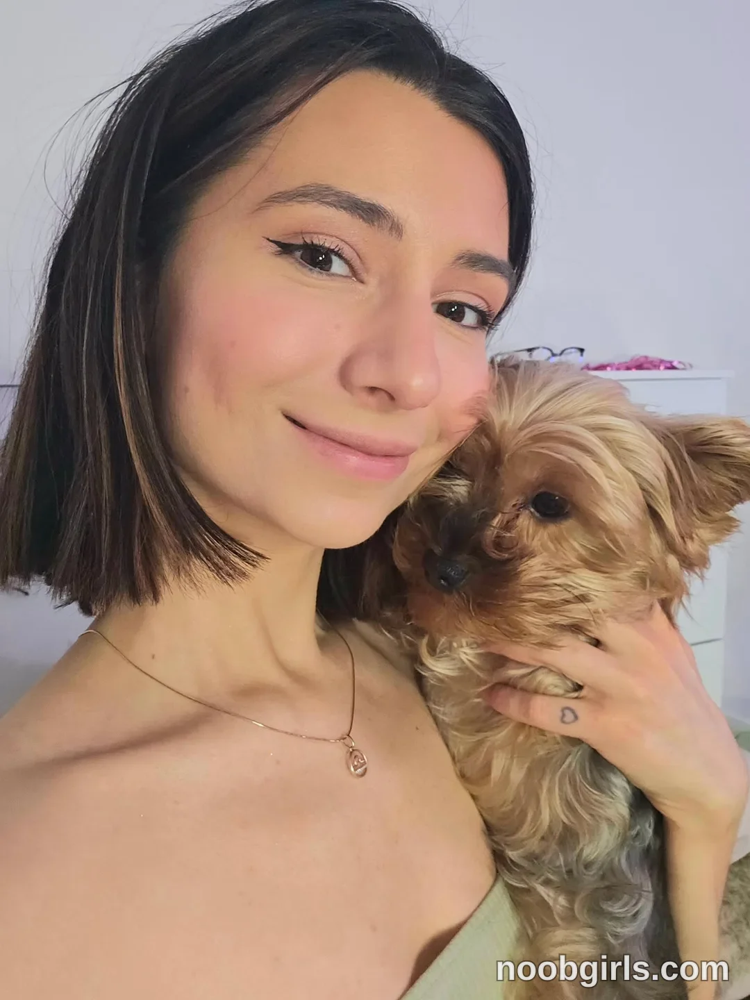 crystalnut holding a small dog wearing light green top