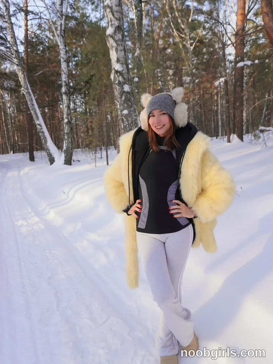 crystalnut standing with hands on hips wearing yellow fur coat in snowy forest