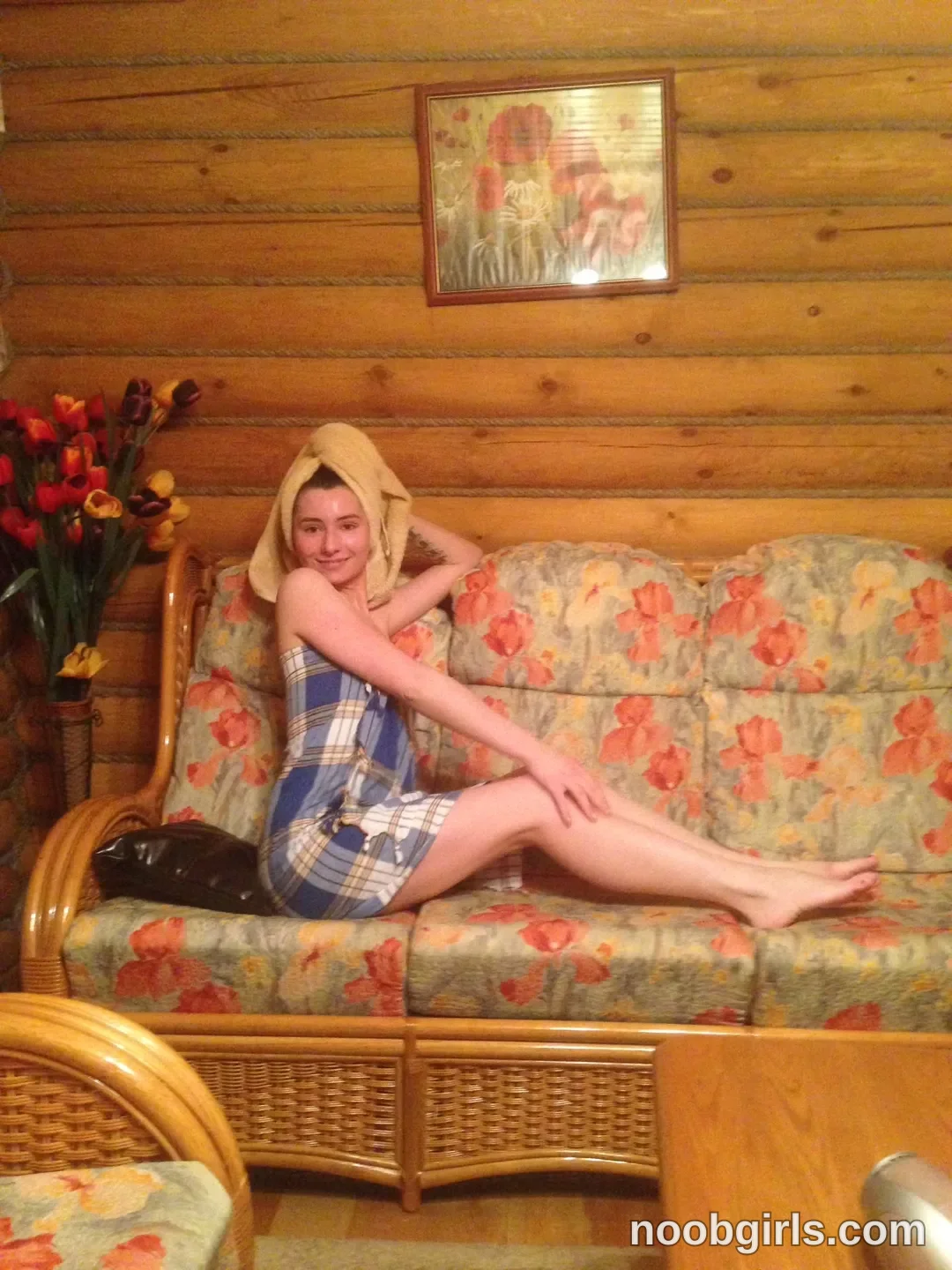 crystalnut reclining on a couch wearing blue plaid towel wrap in log cabin interior