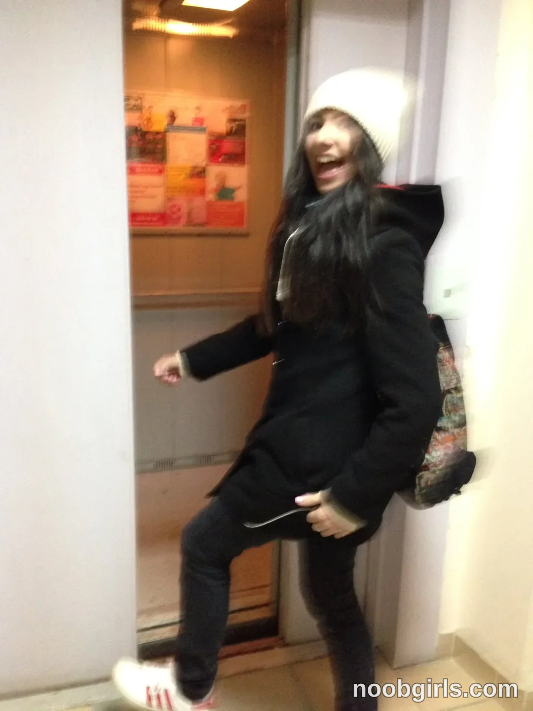 crystalnut stepping out of an elevator wearing white beanie in elevator entrance