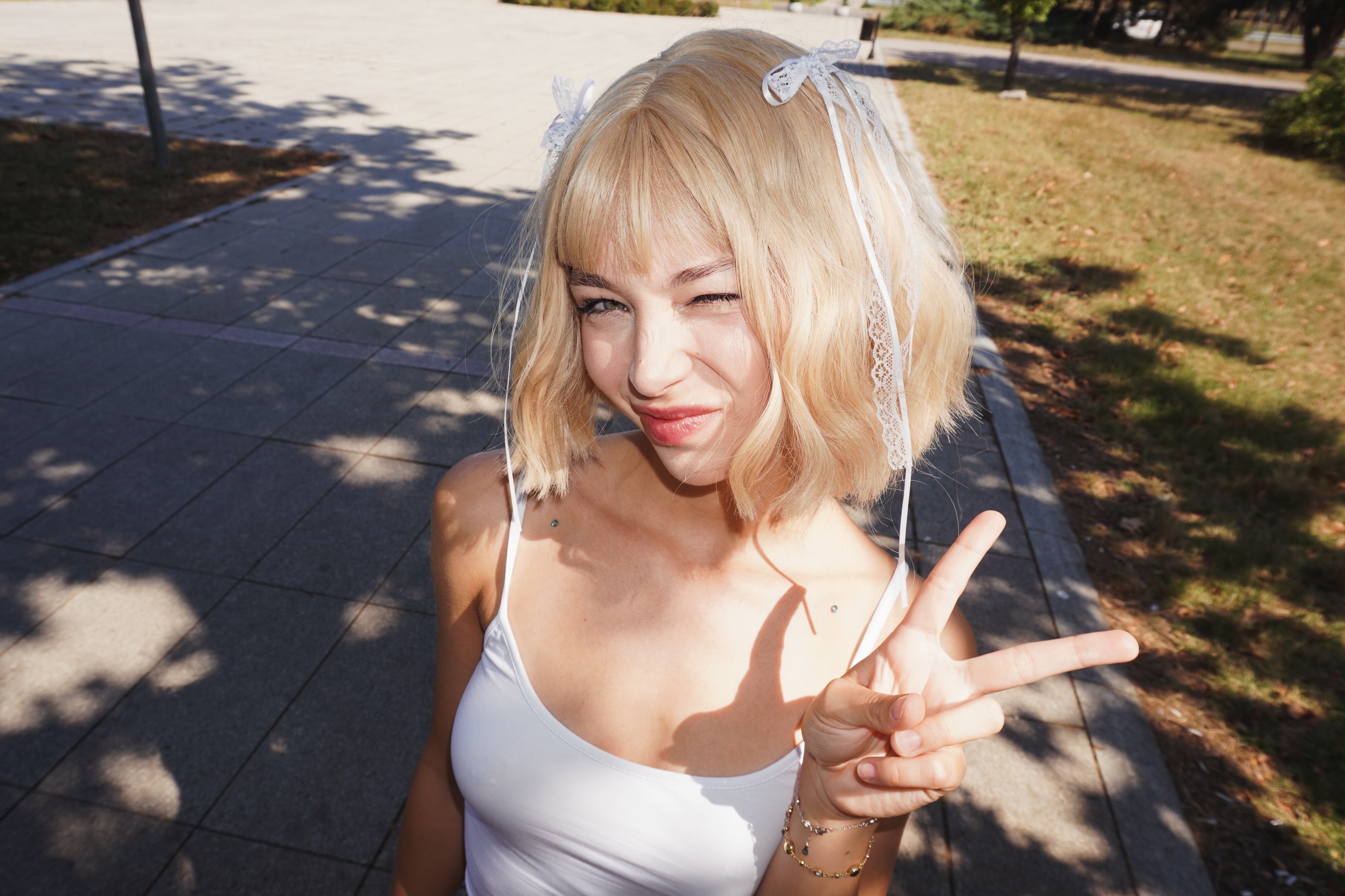 cutieeeeva winking wearing white tank top in park walkway