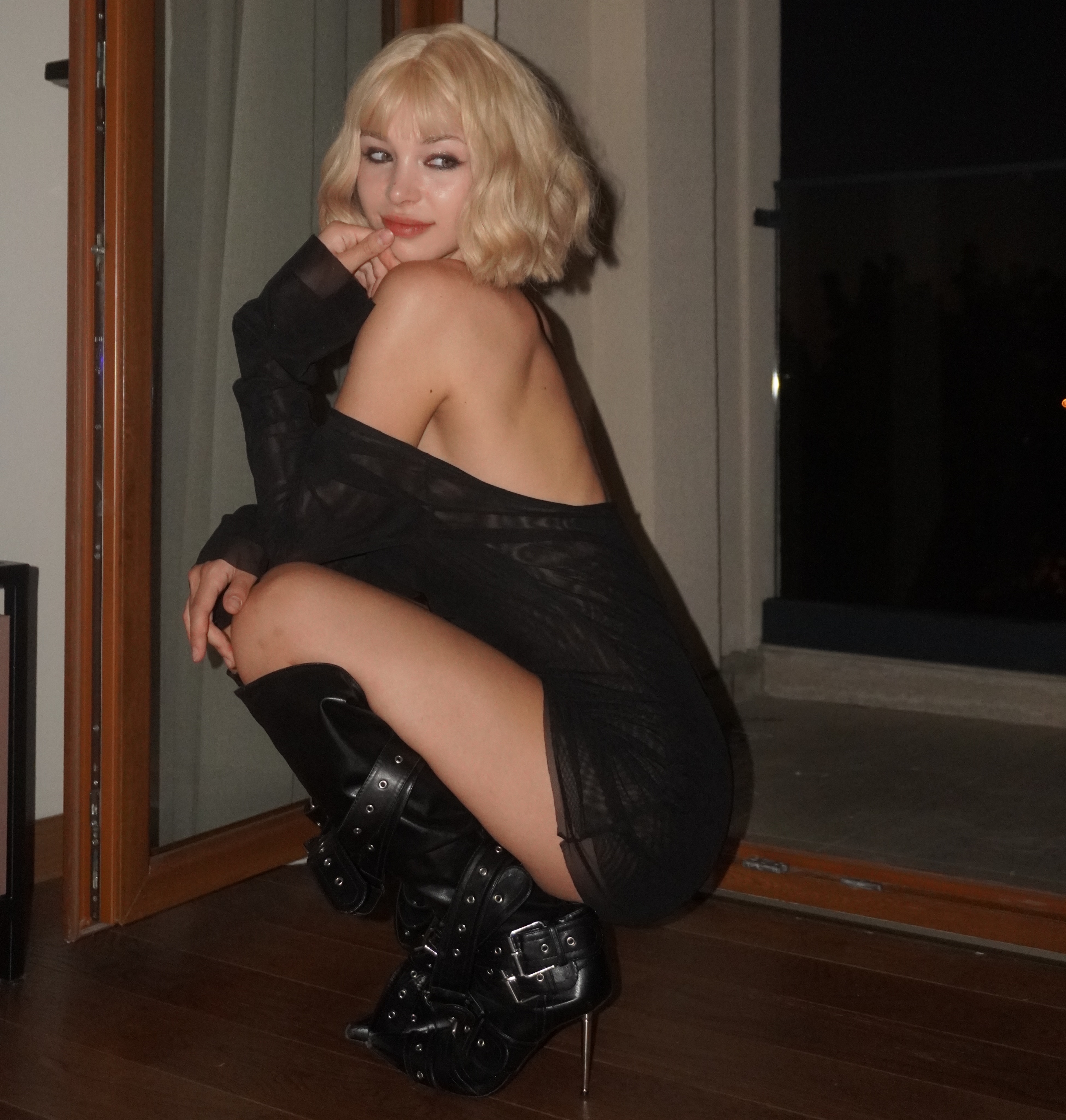 cutieeeeva crouching wearing black sheer backless dress in room near balcony