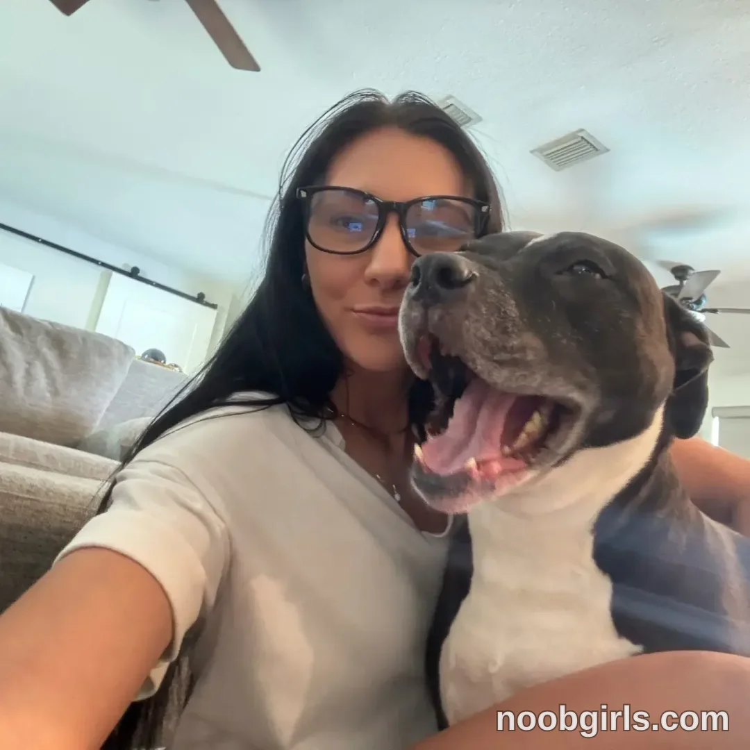 Dazey taking a selfie with a dog wearing white t-shirt in living room