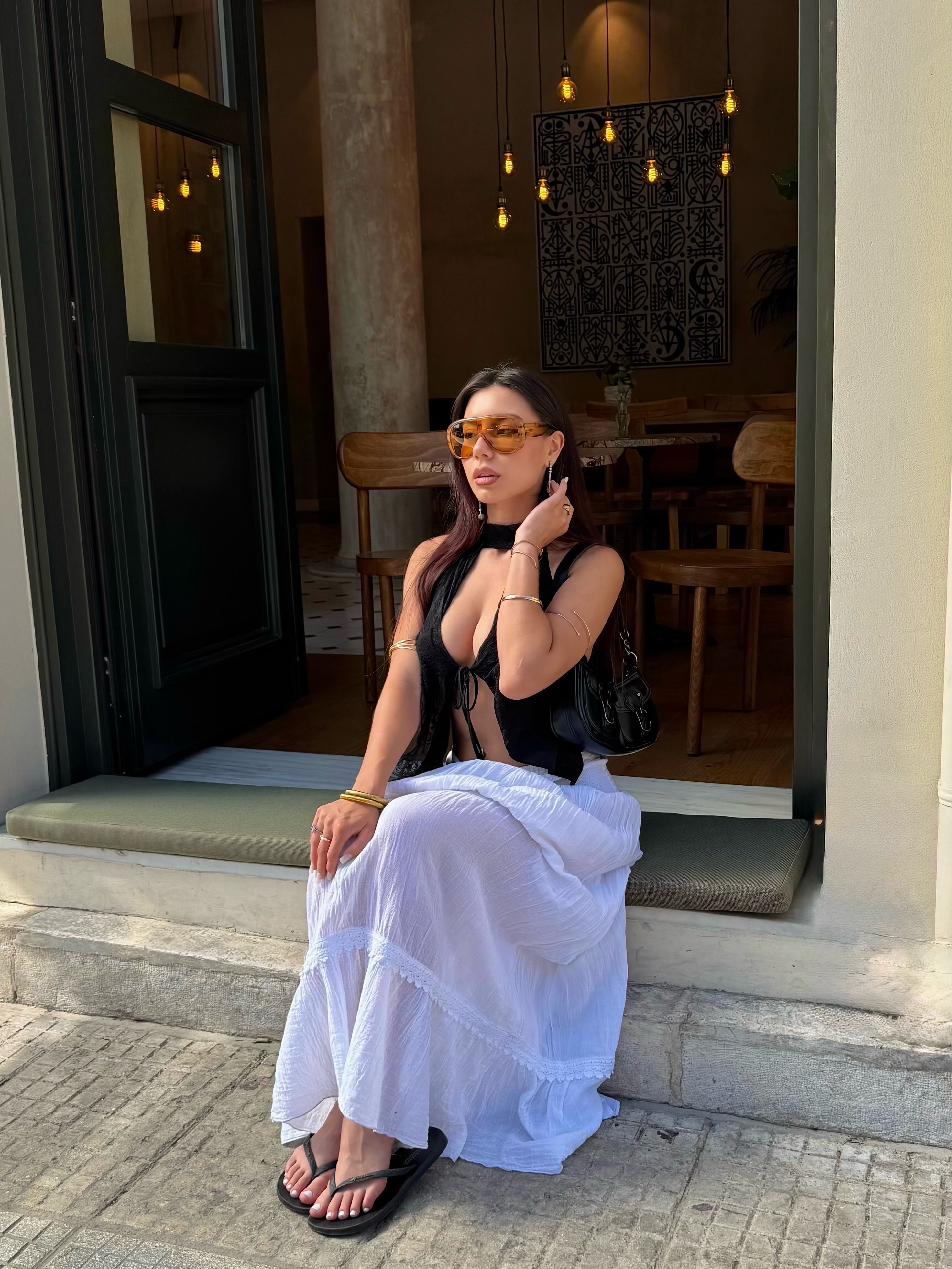 deniseglows sitting on a doorway ledge wearing black halter top in cafe entrance