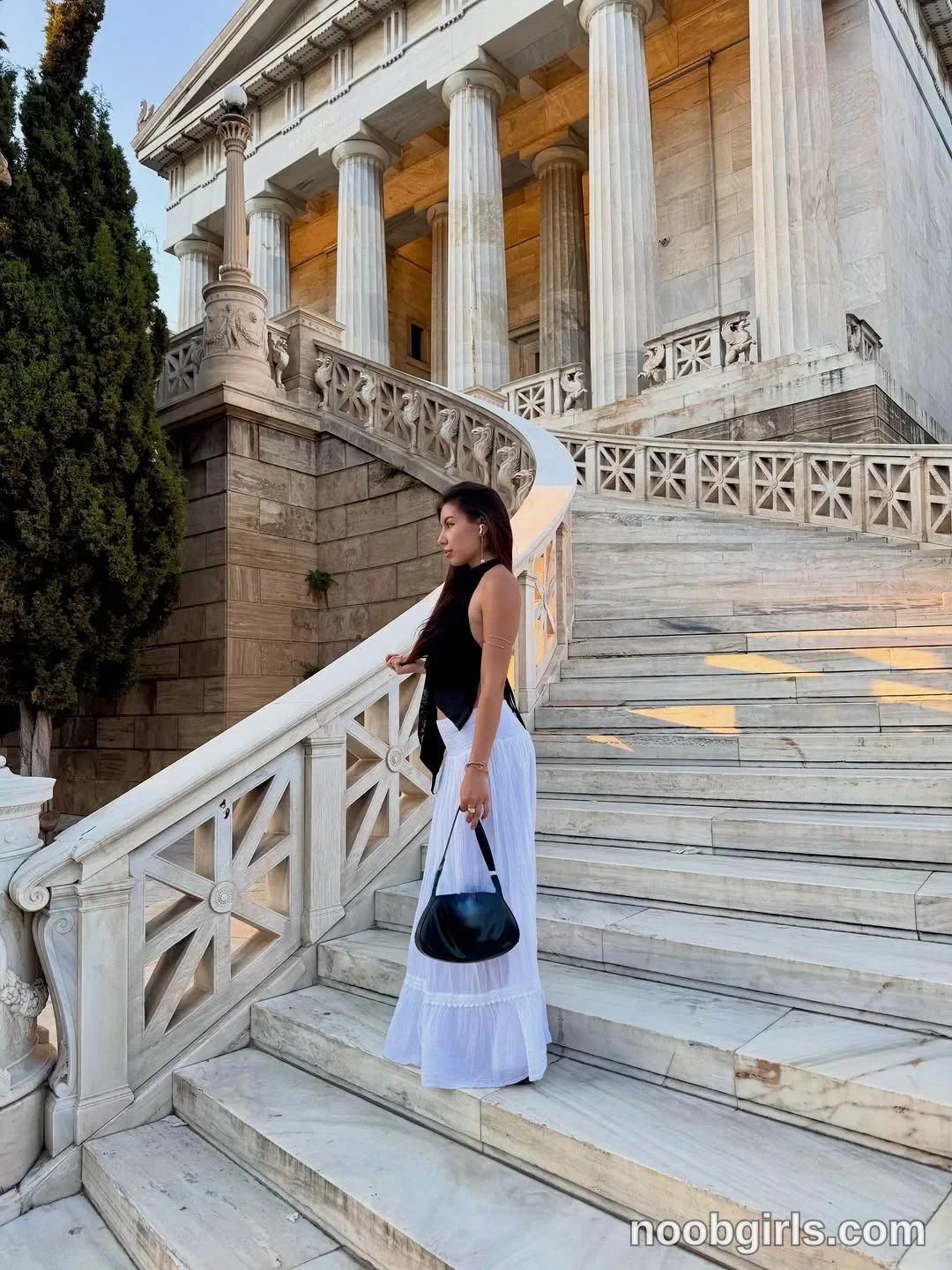deniseglows Standing sideways on the stairs wearing Black sleeveless top in marble staircase beside a building