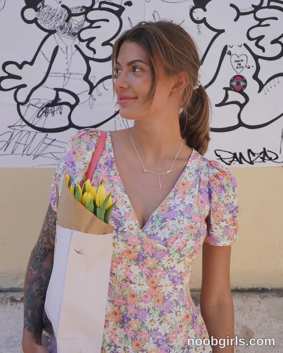 dreamana standing with a wrapped bouquet against her torso