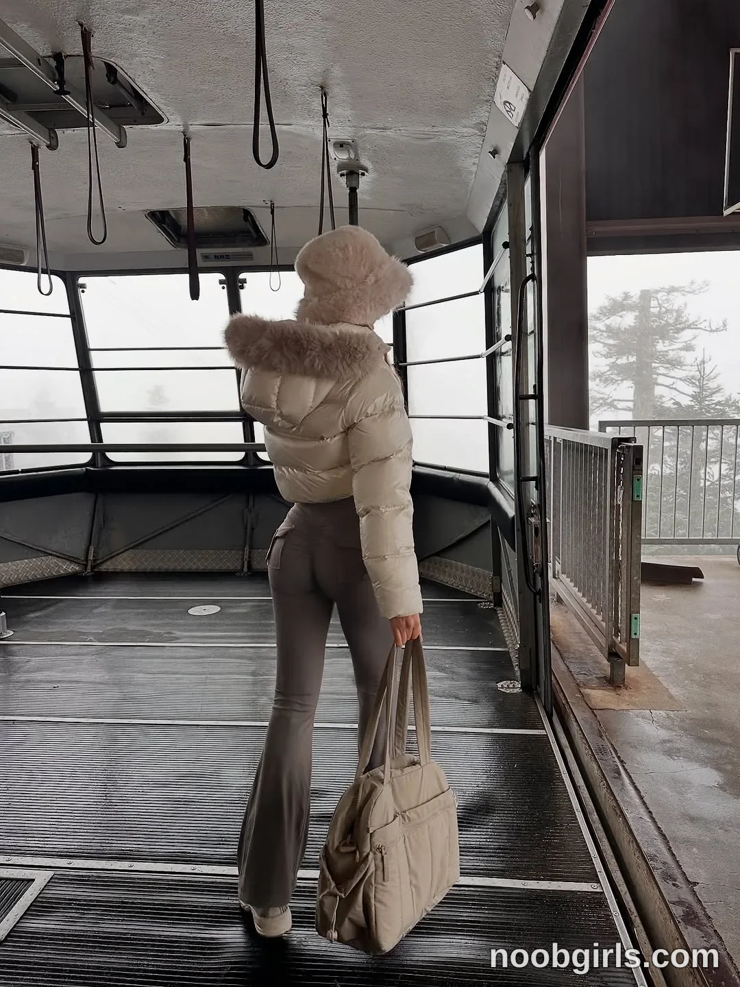 Lilah standing facing away from the camera looking toward the open door of the cable car