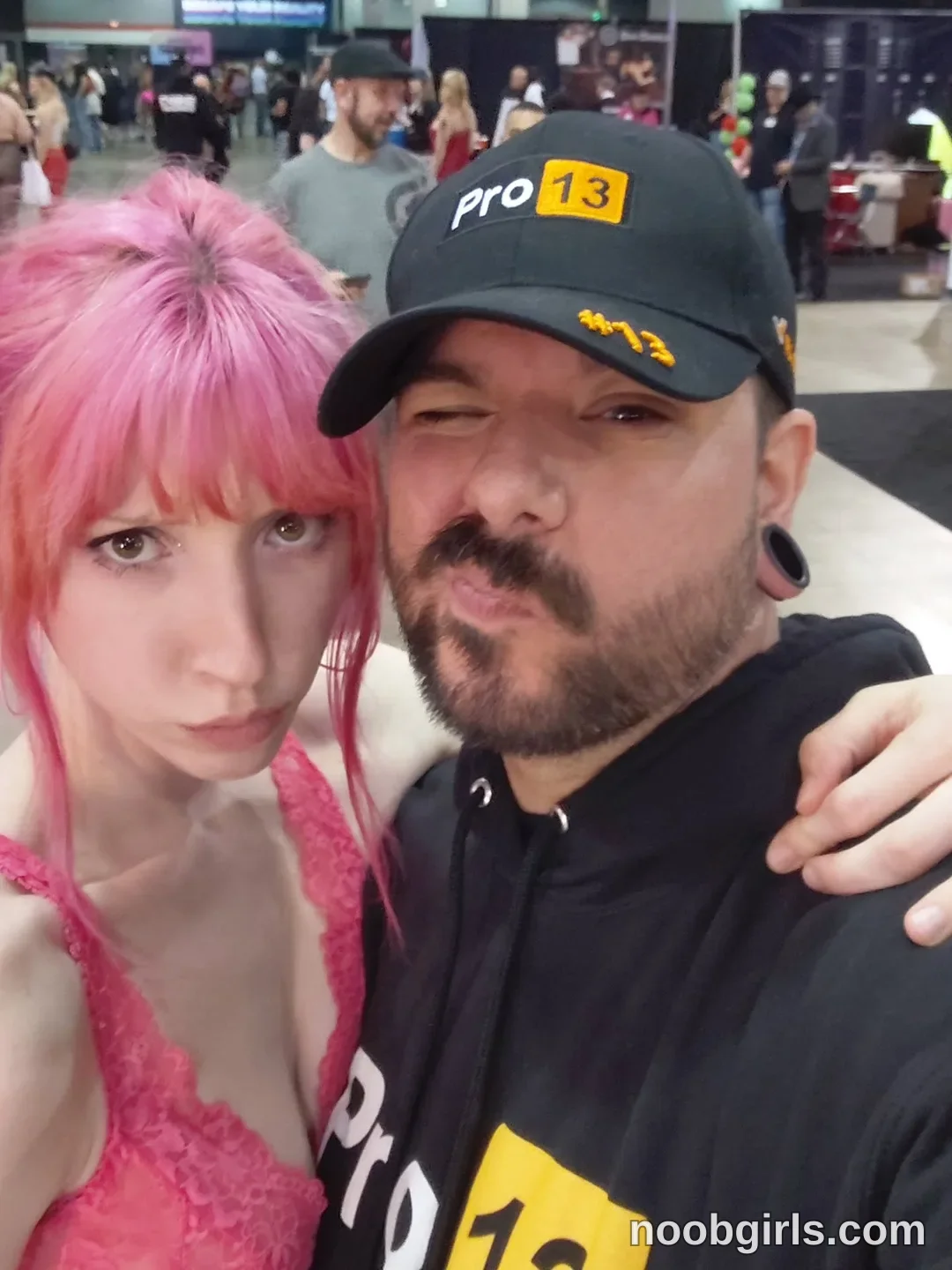 Els taking a selfie together wearing pink lace top in convention hall