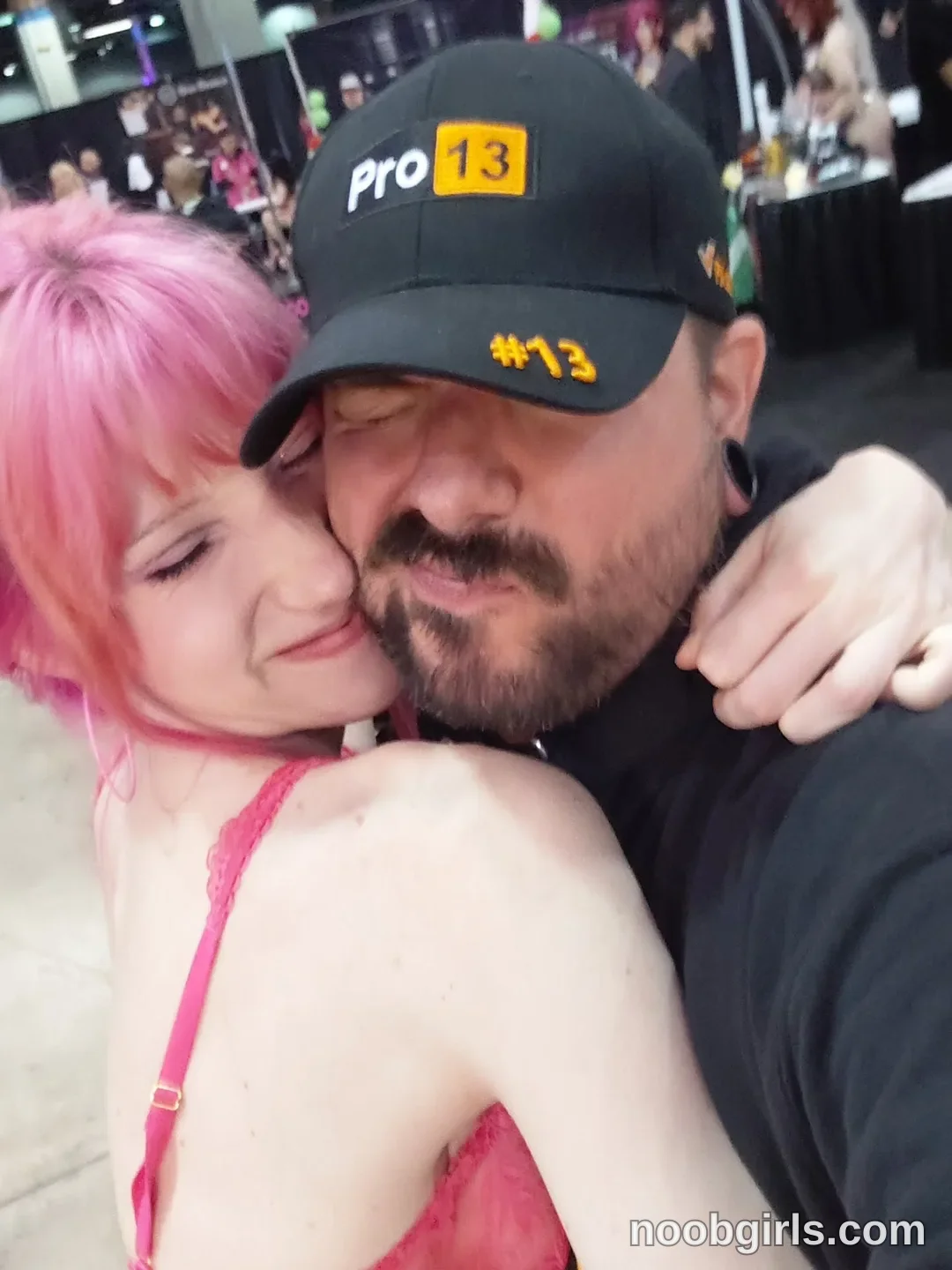 Els hugging wearing pink top in convention hall