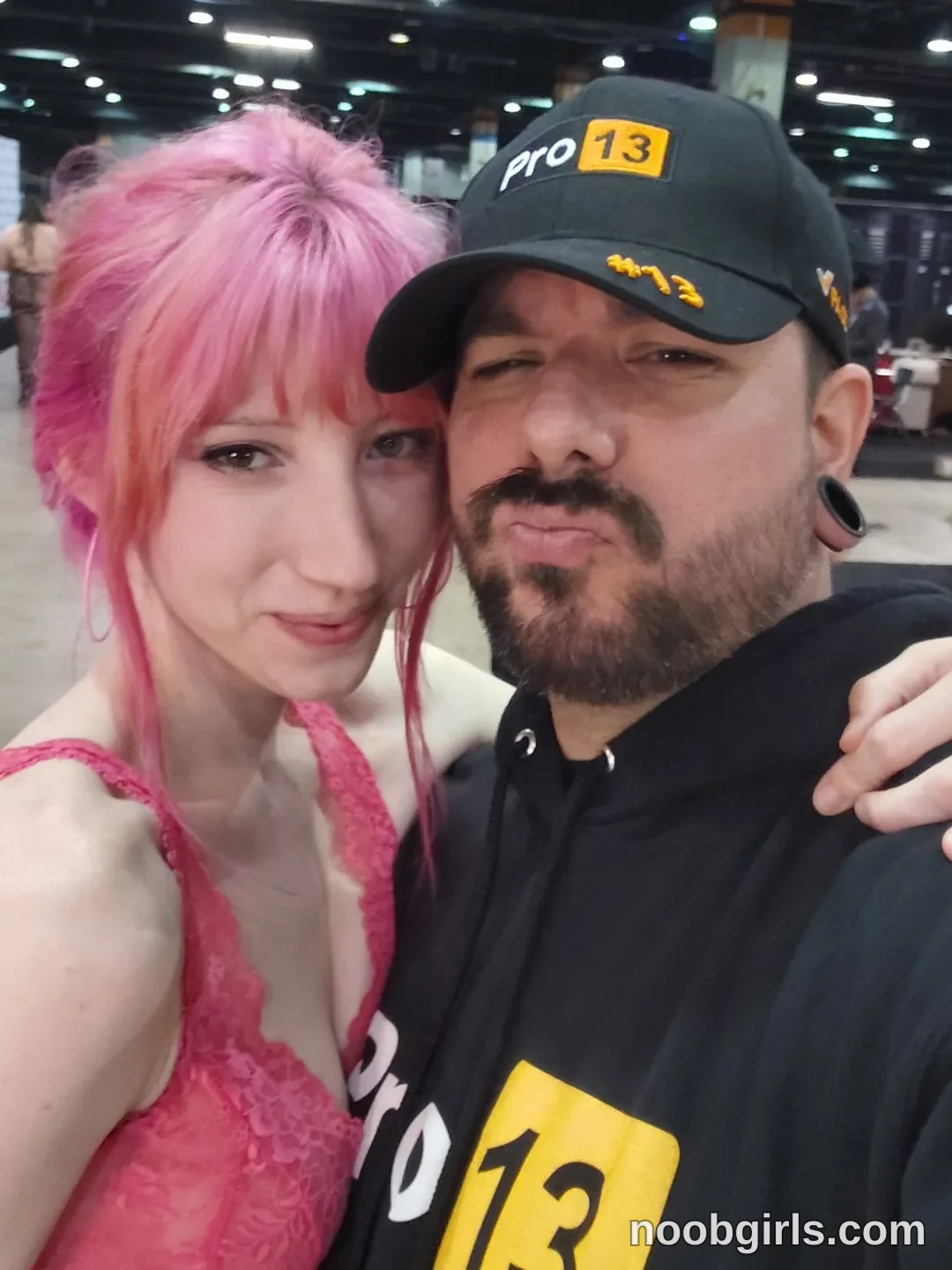 Els taking a selfie together wearing pink lace top in convention hall