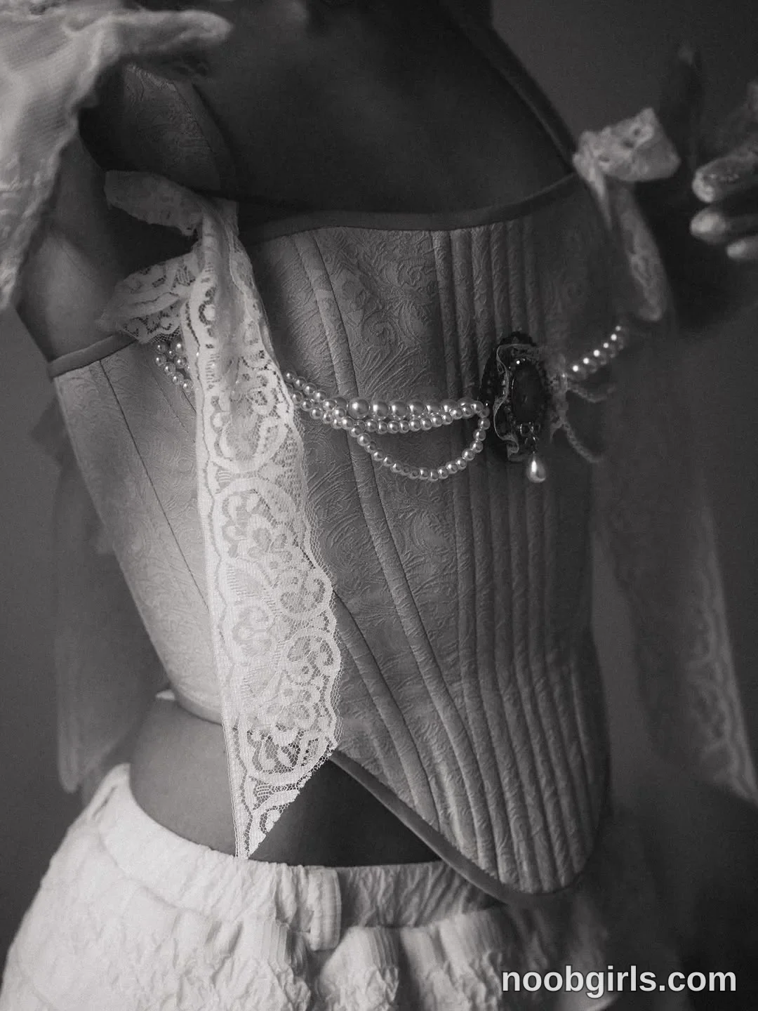 Molly Holding both hands near the upper edges of the corset