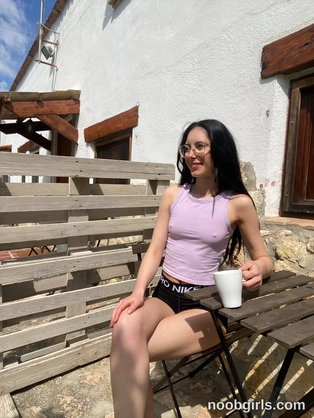 Nikki Gia Sitting on a chair beside the table wearing Light purple sleeveless top