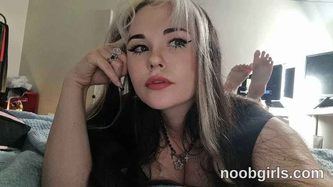 MissTery Lying on her stomach on a bed wearing Black short-sleeved top in bedroom in Vancouver, British Columbia