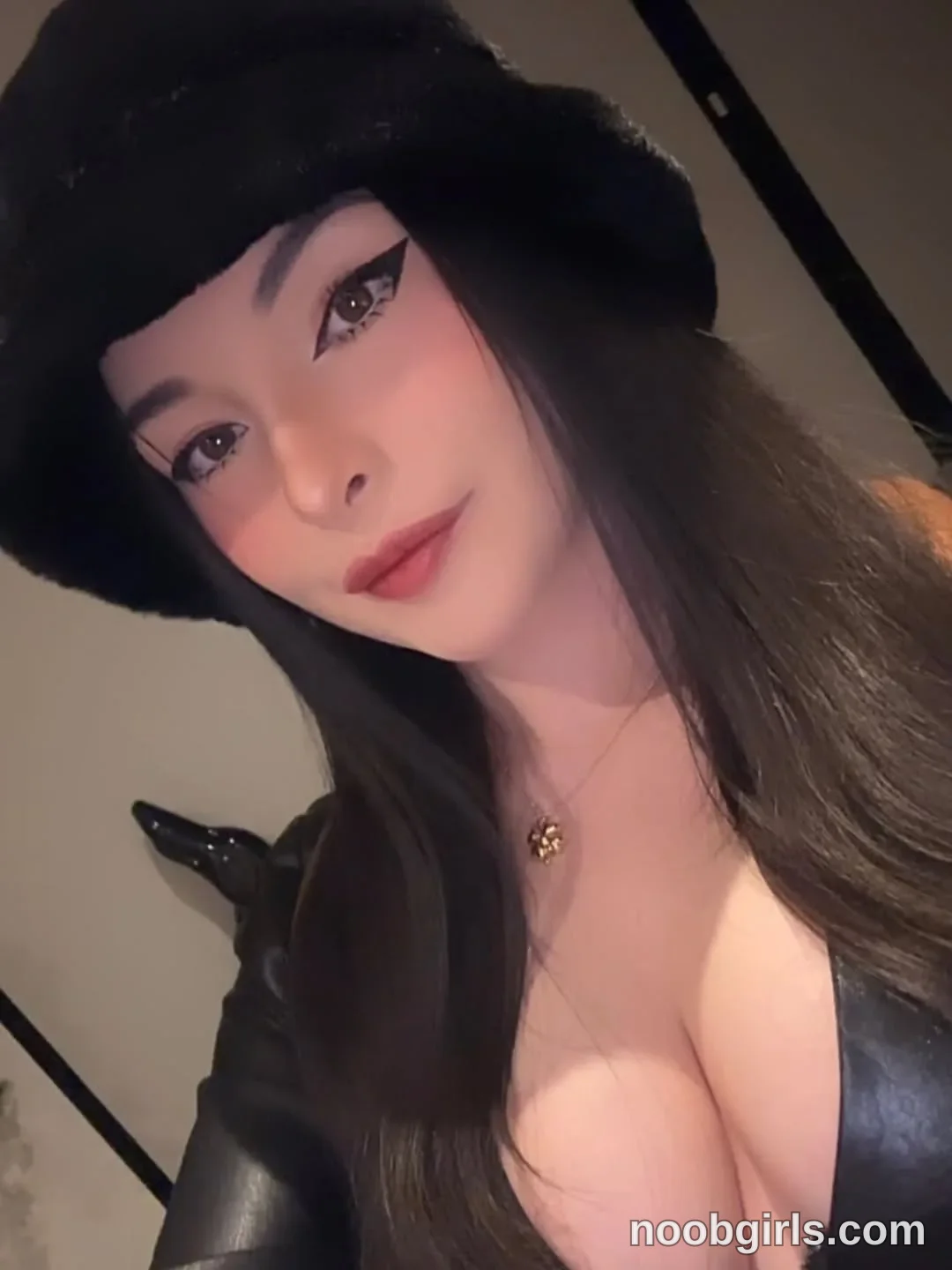 lau__1 Facing the camera with her head tilted wearing Black fuzzy hat in specific type of room not identifiable