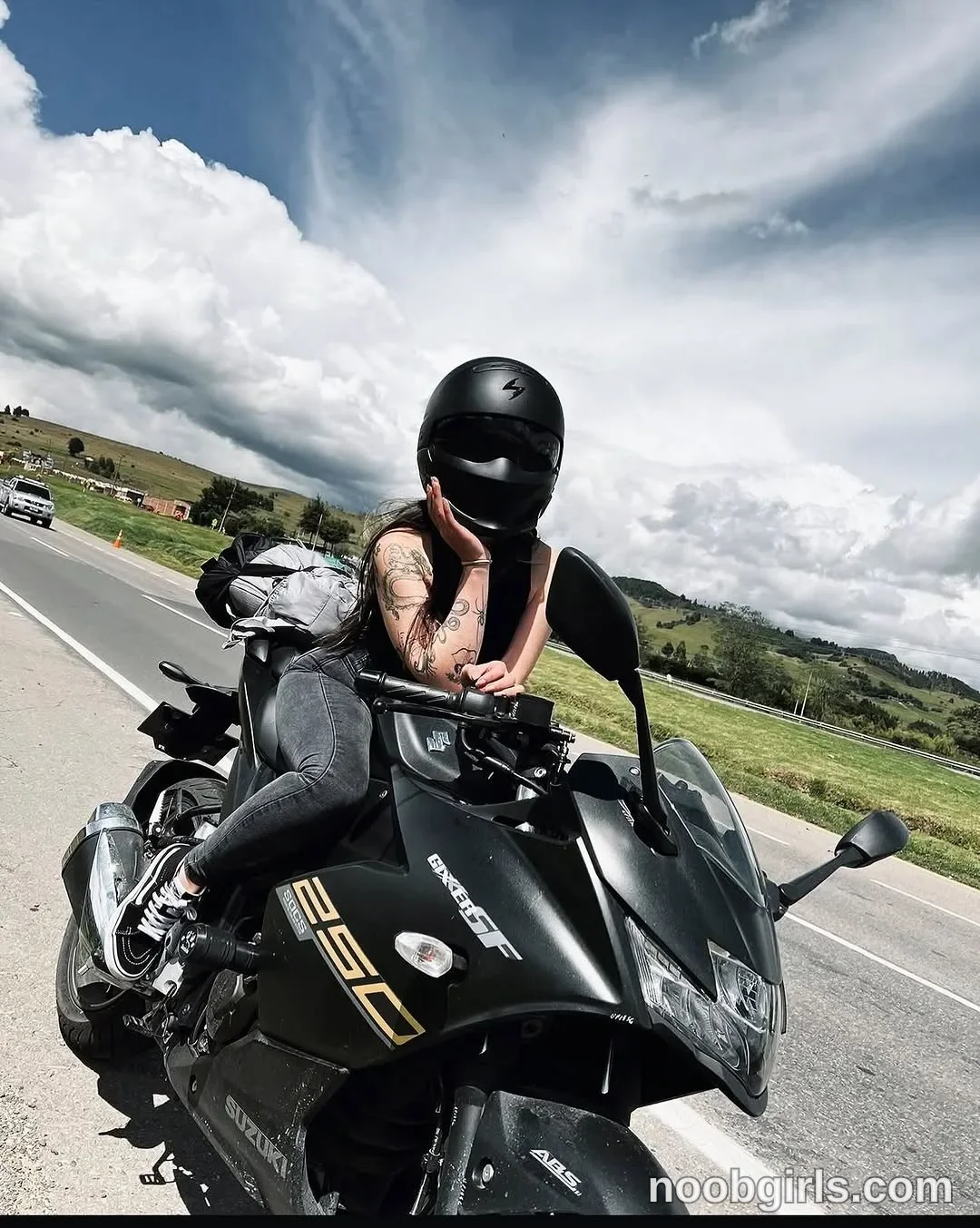 lau__1 Sitting astride the motorcycle wearing Black full-face motorcycle helmet with a dark visor