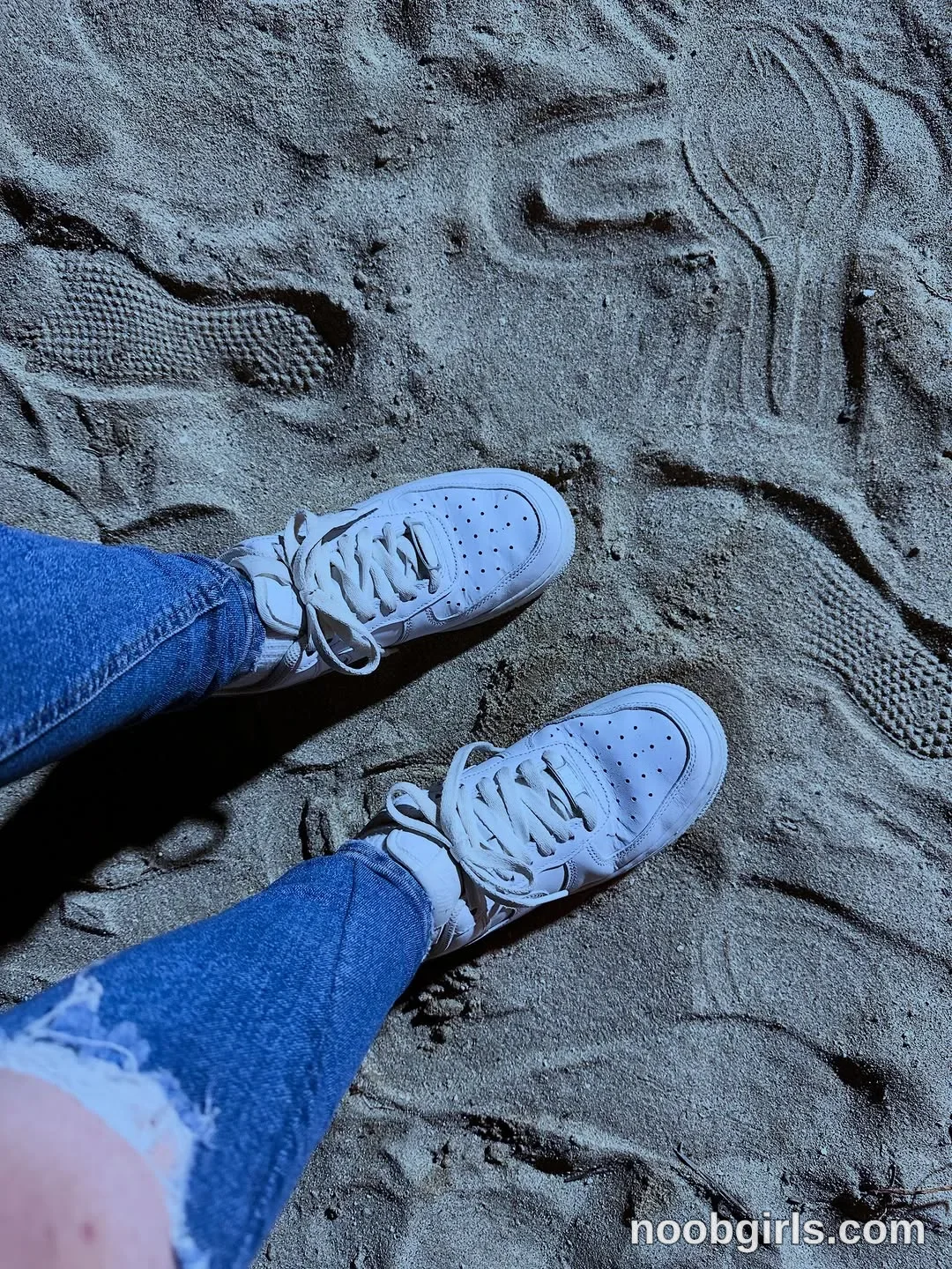 lau__1 Her legs extend into the frame with both shoes resting on the sand