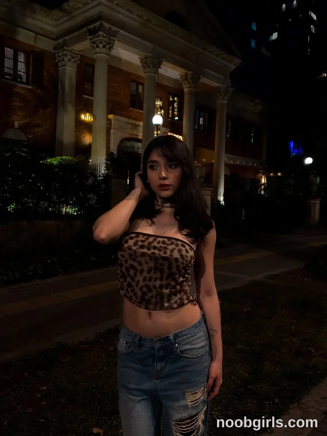 mariannacruzz Standing with one hand touching the side of her head wearing Brown and black leopard-print strapless crop top