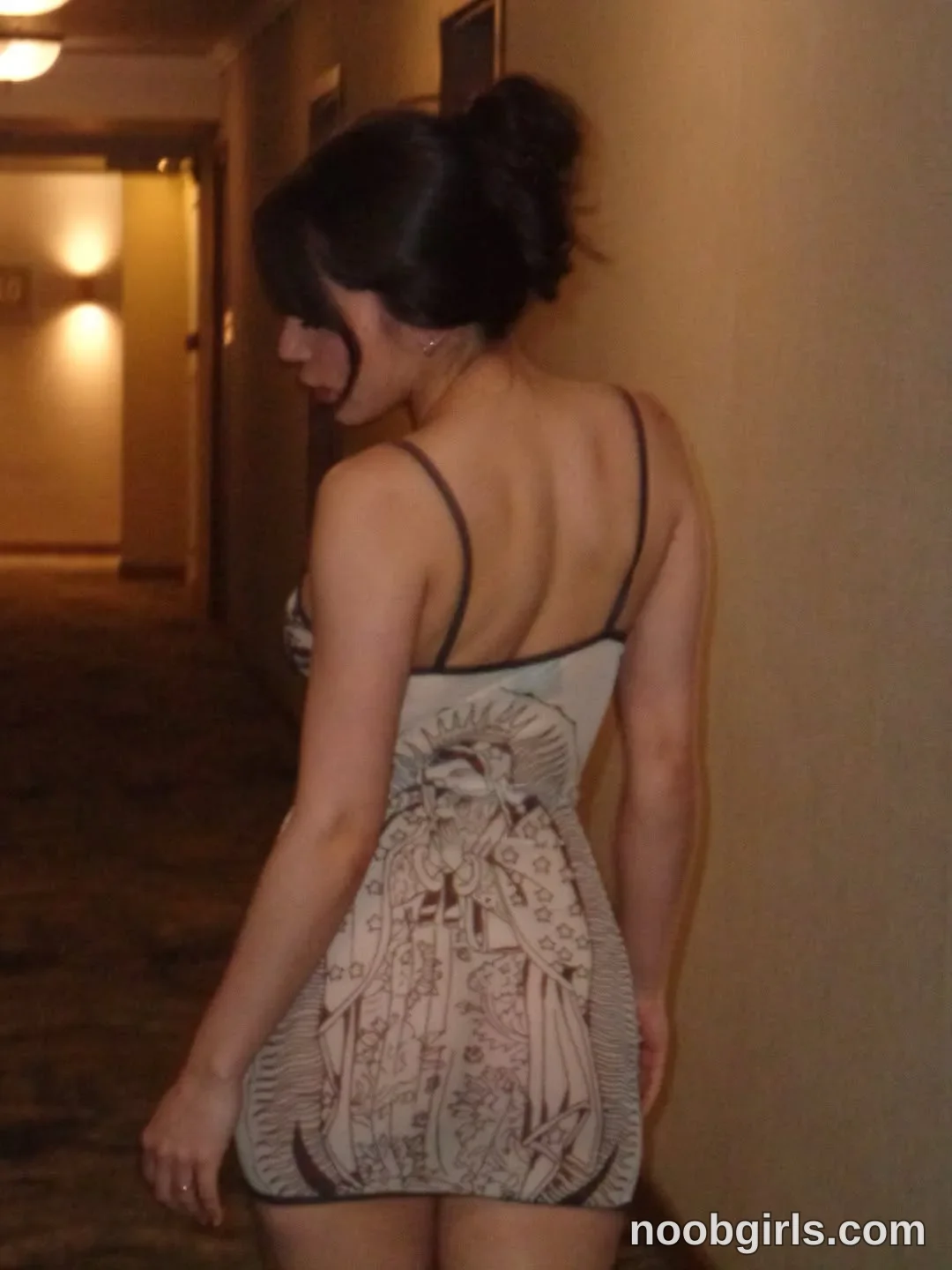 mariannacruzz Standing beside a wall with her back toward the camera