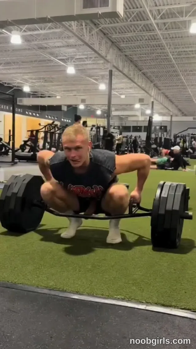 Mia Grey Crouching wearing black sleeveless shirt with red and white lettering in gym