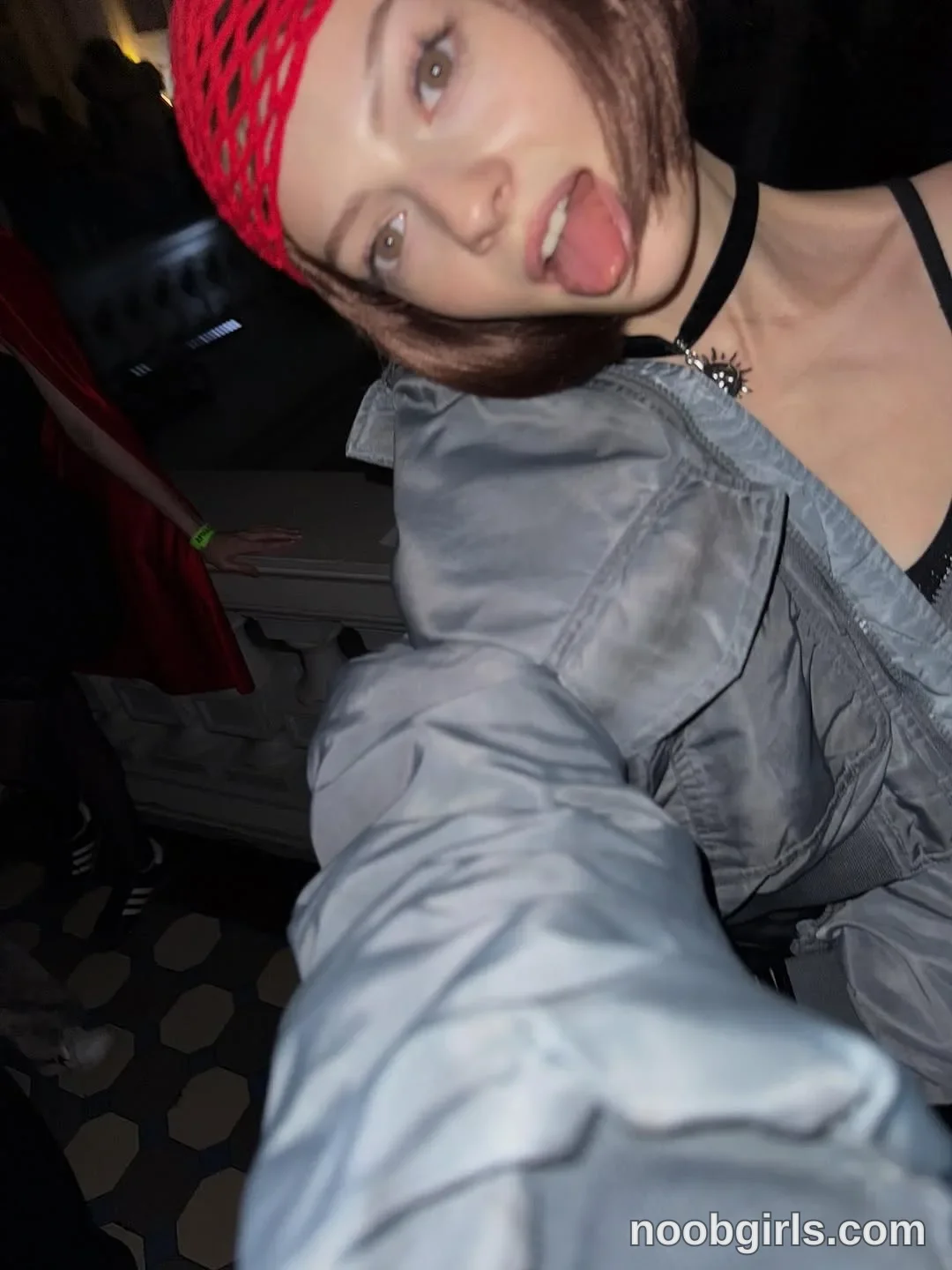 Milly Tilting her head wearing Red open-knit head covering in room