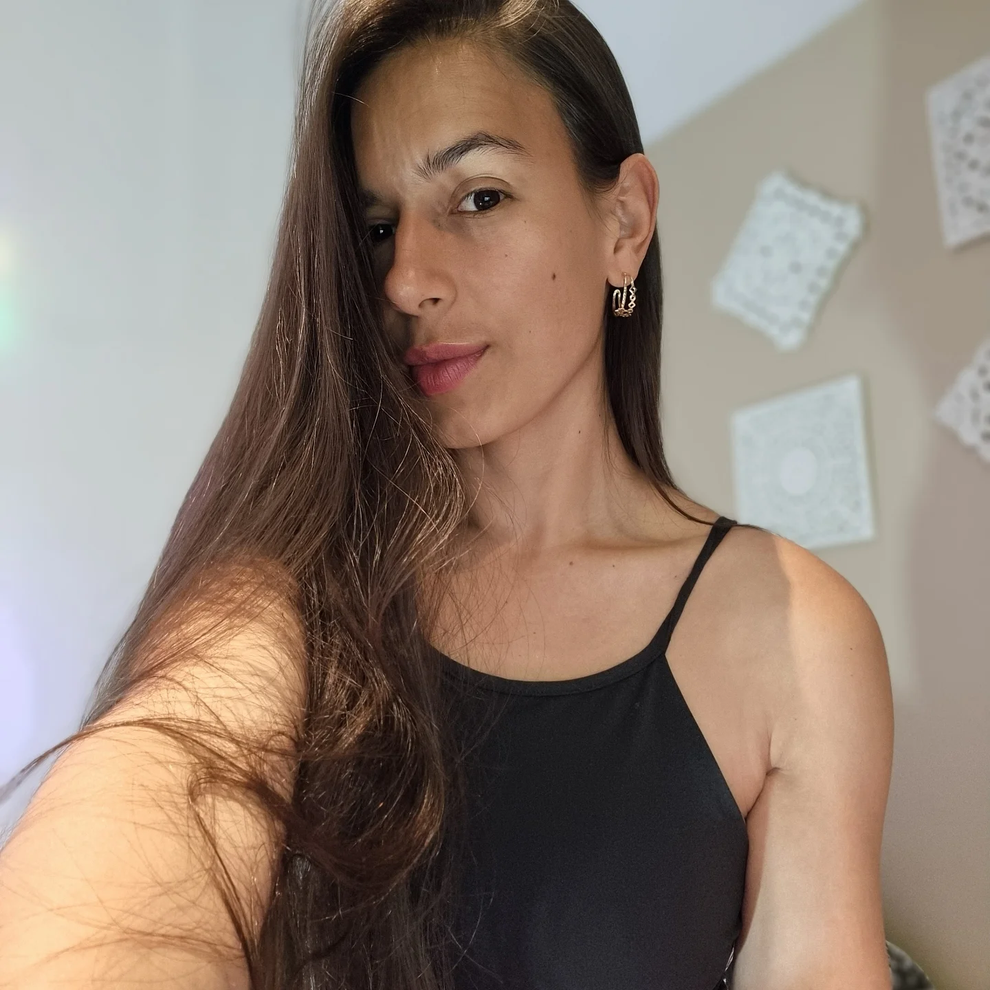 ohanna posing for a close-up selfie portrait wearing black sleeveless spaghetti-strap top in room