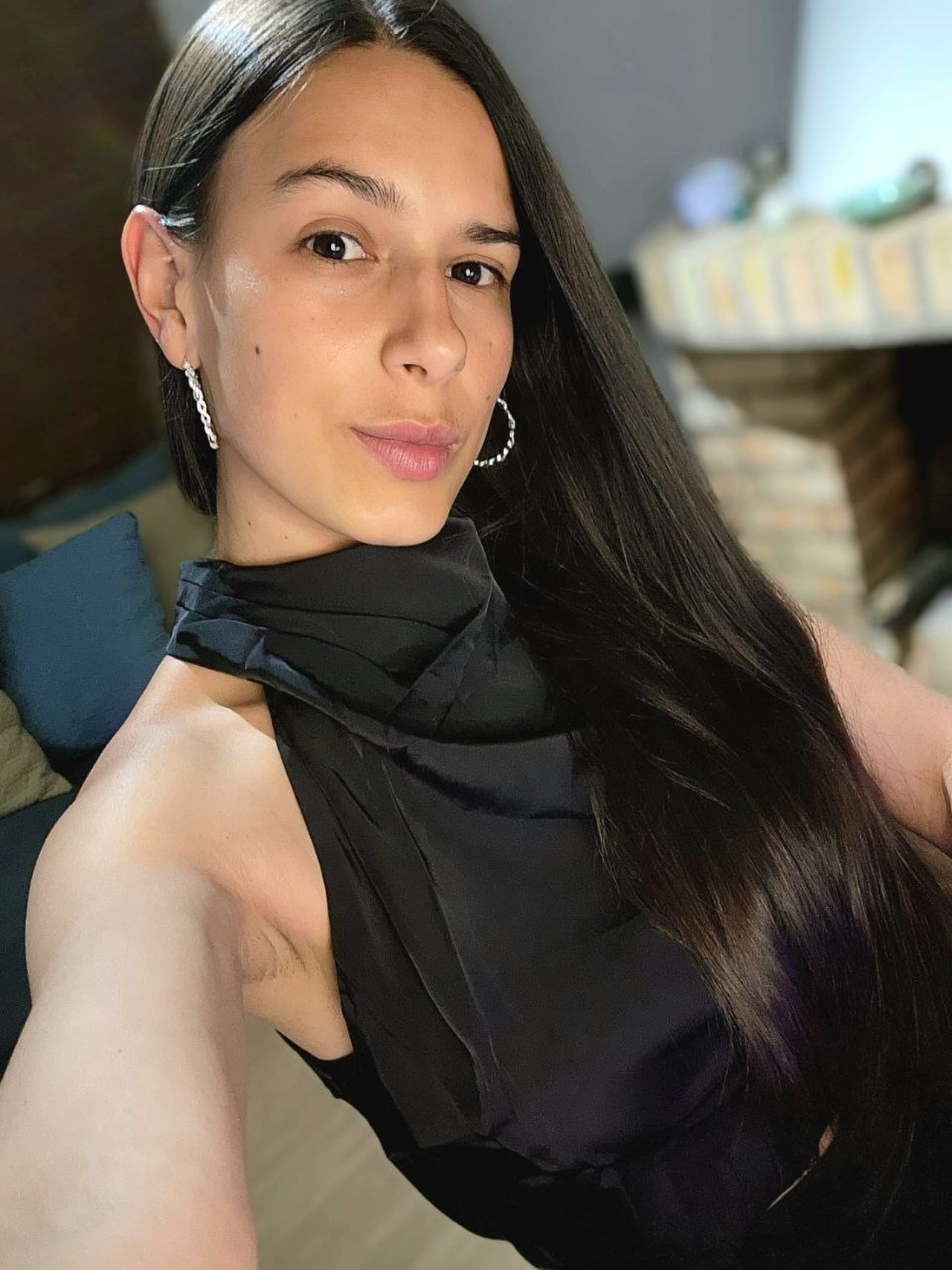ohanna taking a selfie wearing black sleeveless high-neck top in residential room