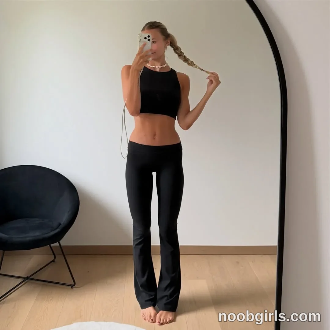 Xena Standing barefoot in front of a mirror wearing Black sleeveless crop top in room in Belgium, Europe