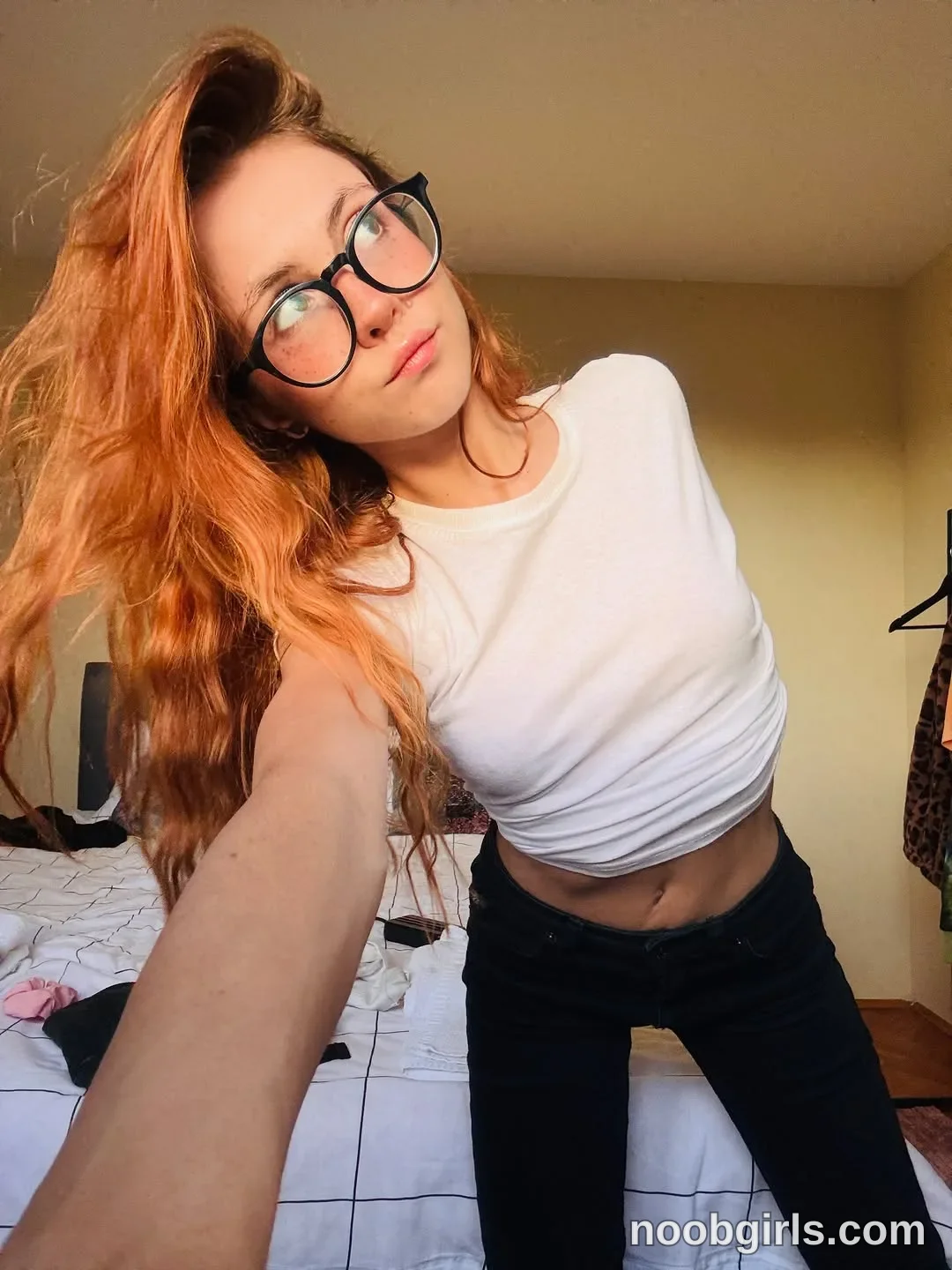 Pinkypupa-Love Leaning toward the camera with one arm extended toward it wearing White short-sleeved cropped T-shirt