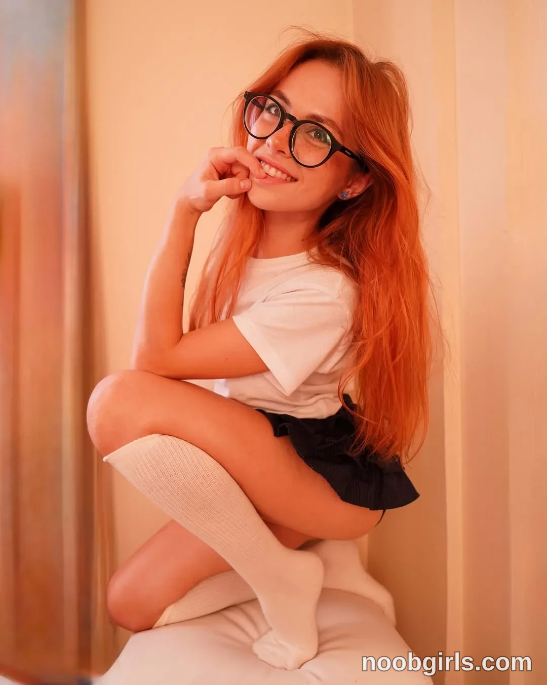 Pinkypupa-Love Posing on a padded seat with her legs bent wearing White short-sleeved T-shirt in front of curtains