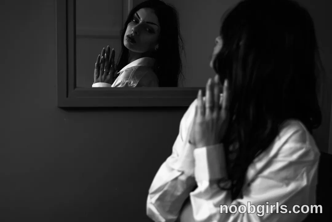 Queen Pinky sitting or standing facing a mirror with palms pressed together in front of the chest