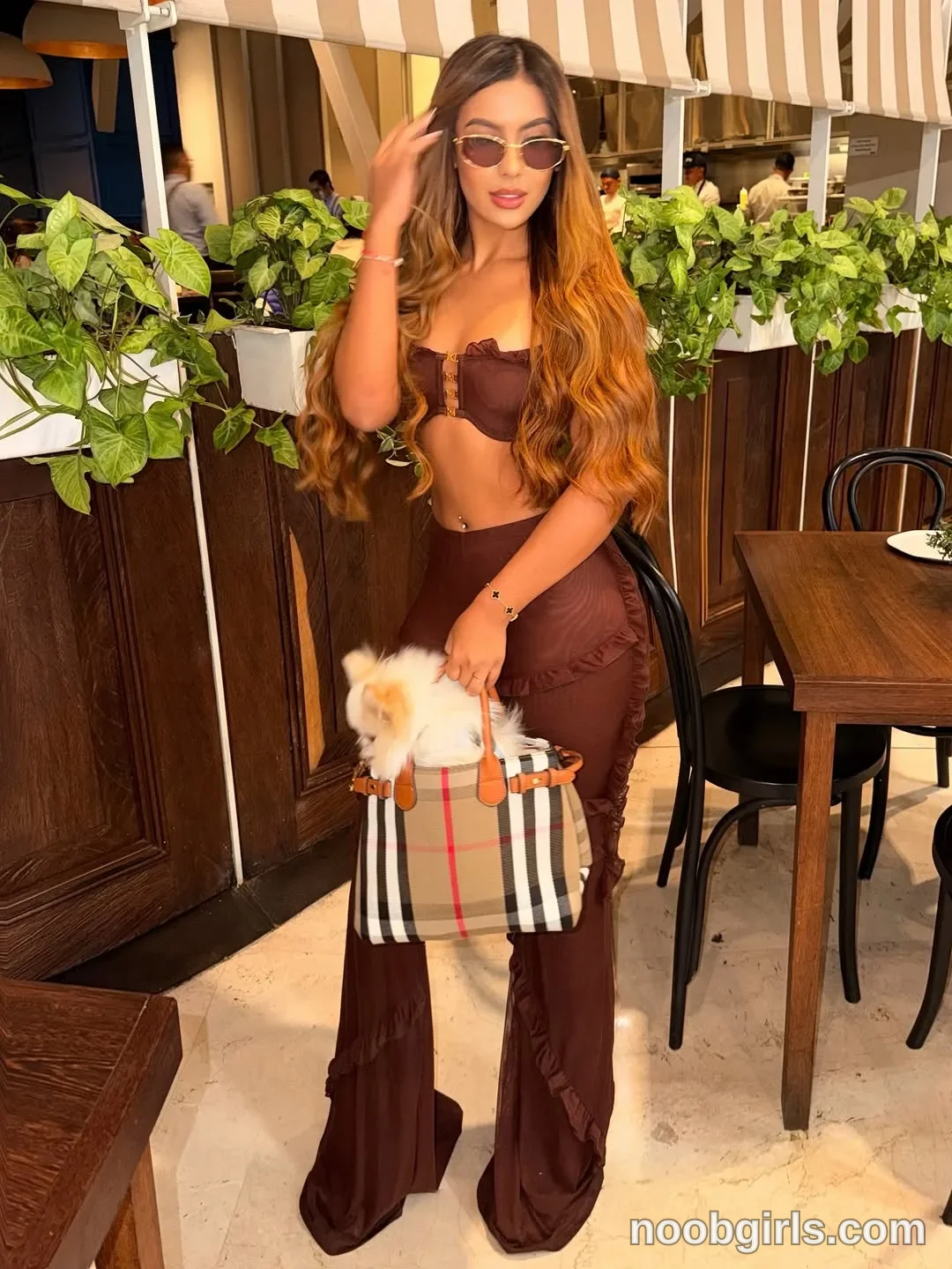 sary_hott wearing brown strapless crop top with ruffle trim and gold-tone center hardware in restaurant or dining area
