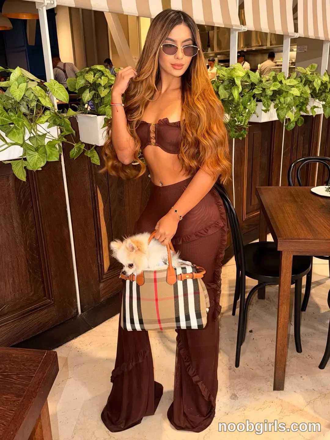 sary_hott wearing brown strapless crop top with ruffle trim and front metal hardware in restaurant or dining area
