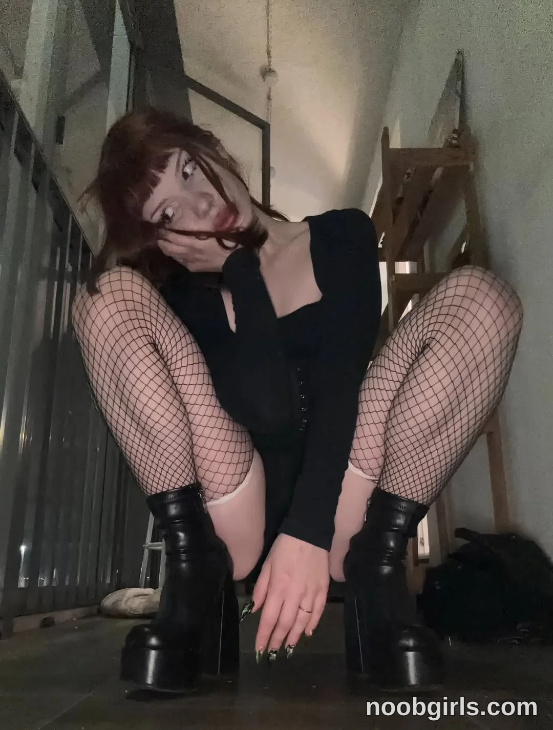 Jo Squatting with knees spread wearing Black long-sleeved garment with a square neckline in stairwell