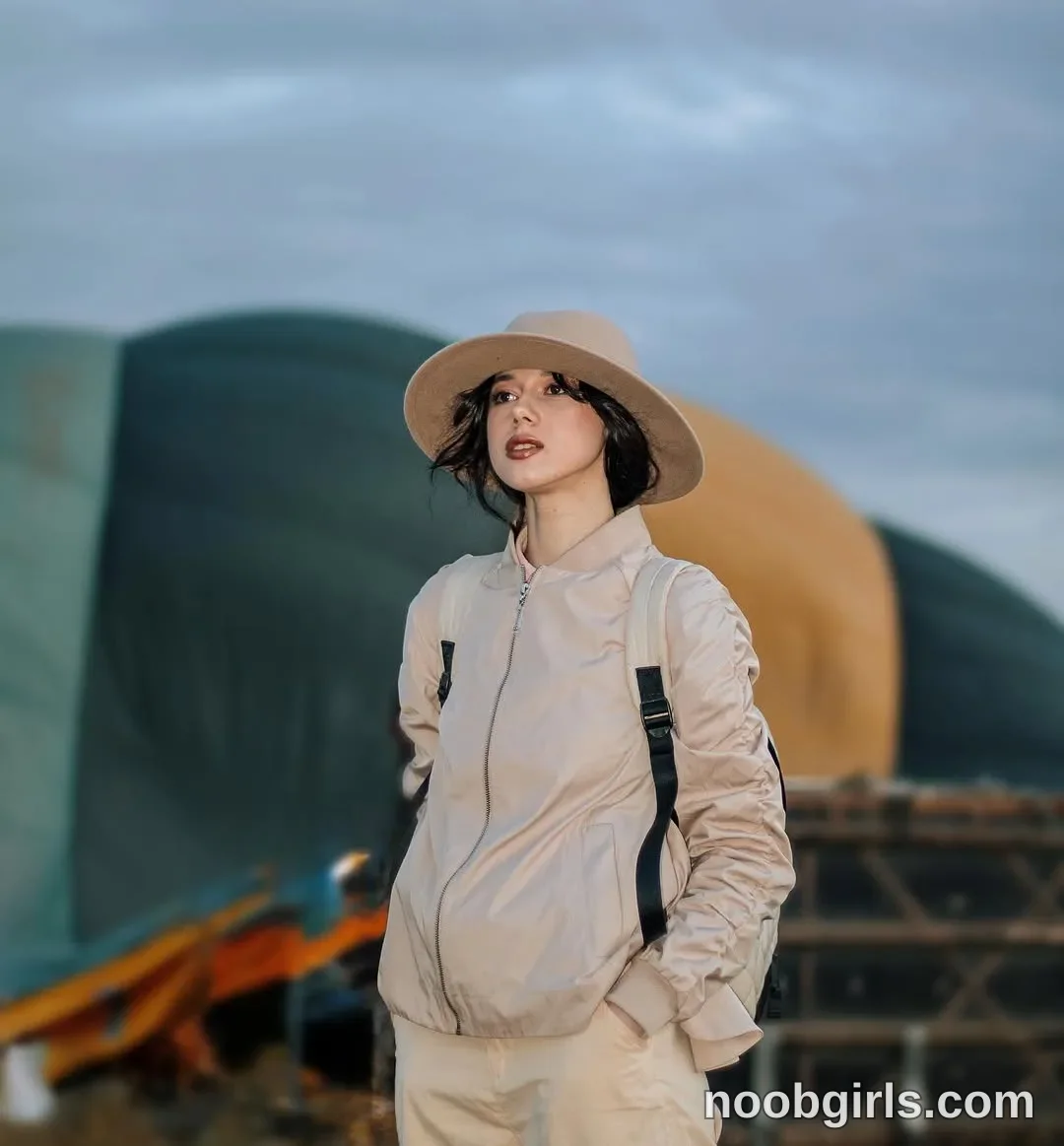 TAANNI Standing with her hands in her trouser pockets wearing Beige wide-brimmed hat in area