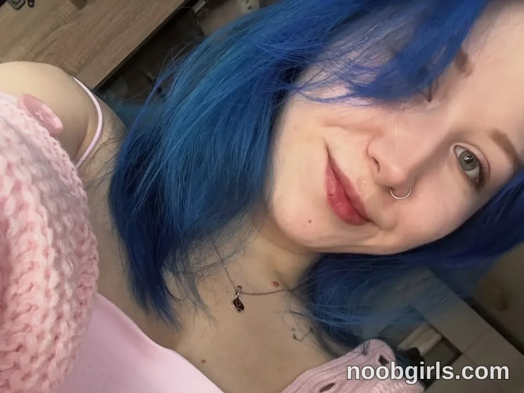 theblue_moonie taking a close-up selfie looking towards the camera wearing light pink spaghetti strap top in room