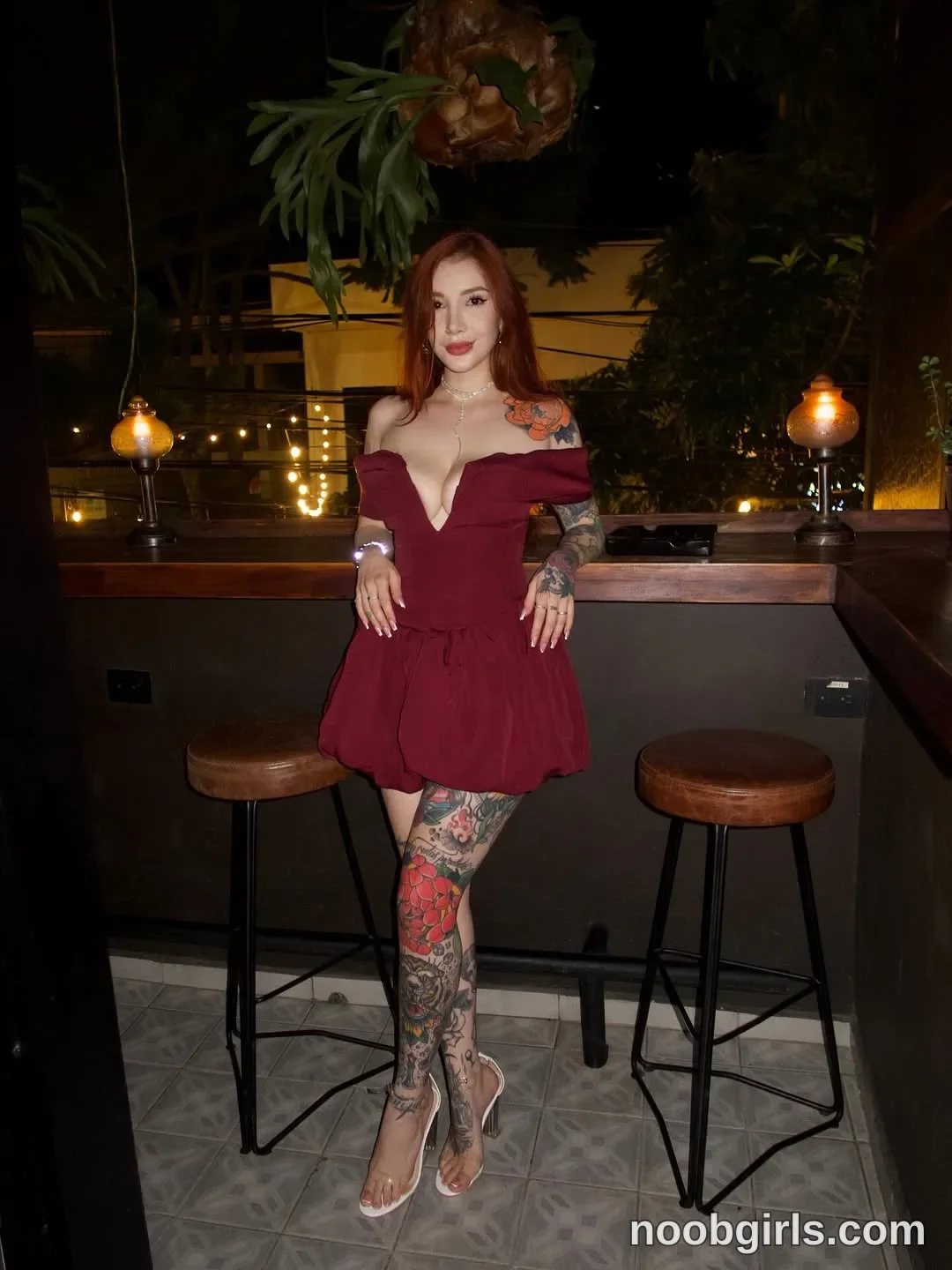 Alicia Standing between two stools with her legs crossed