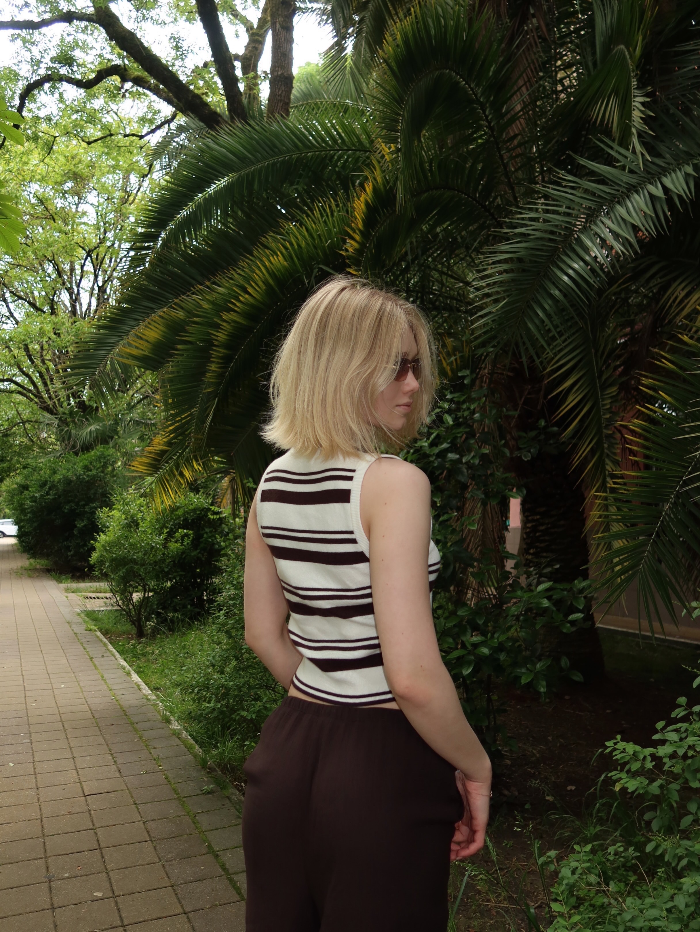 tollysage wearing striped sleeveless top in paved pathway