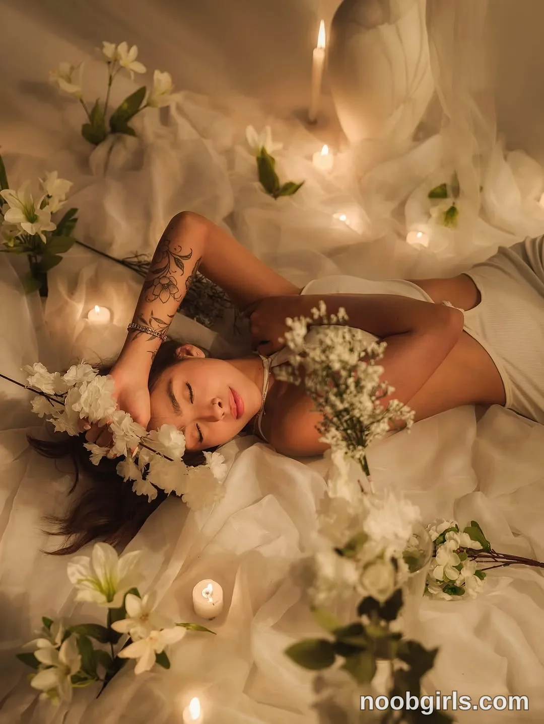 victoria__rossi Lying on her back with her eyes closed wearing White ribbed sleeveless cropped top on a surface covered