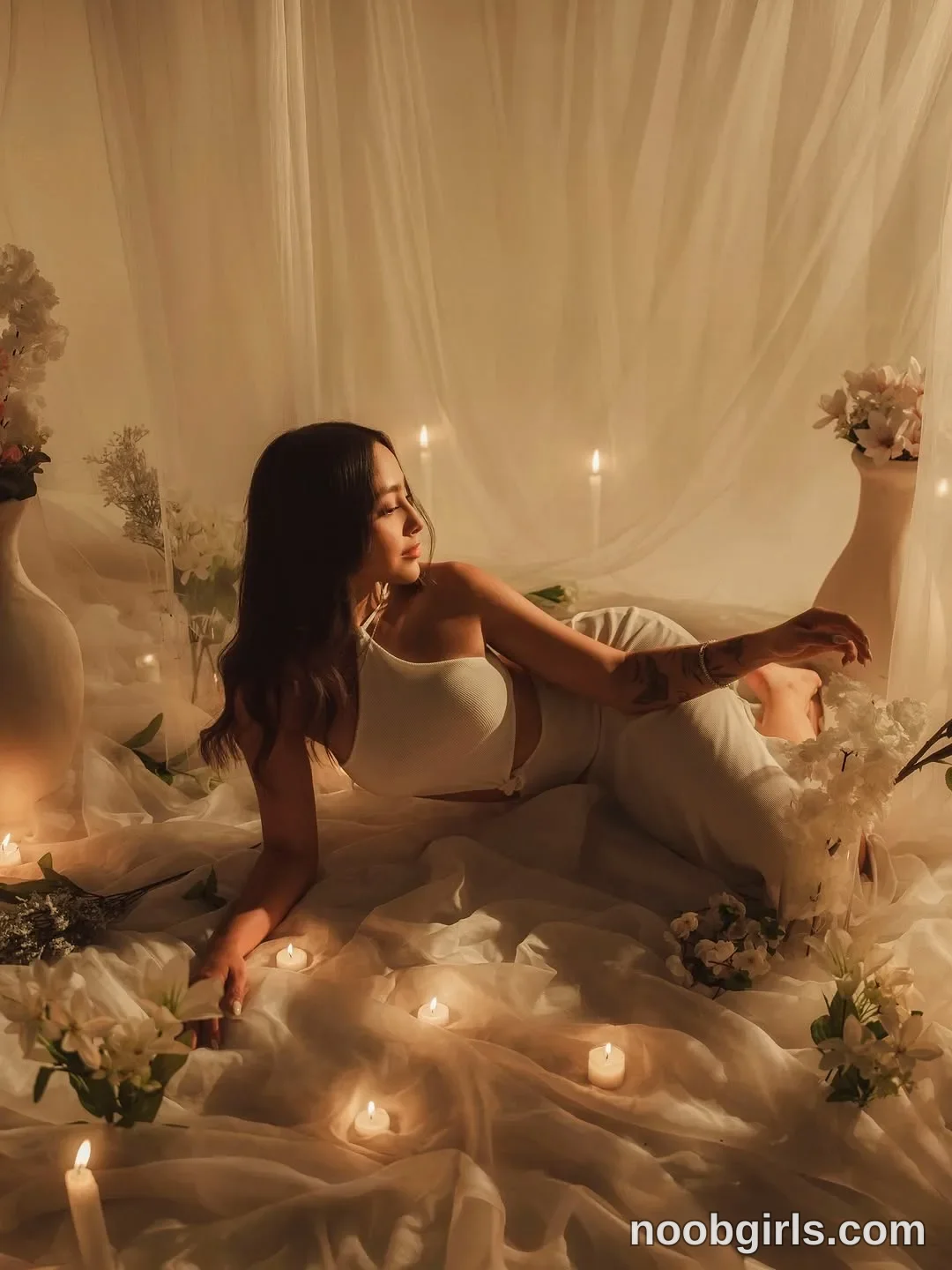victoria__rossi Reclining on the fabric-covered surface wearing White sleeveless cropped top in staged area