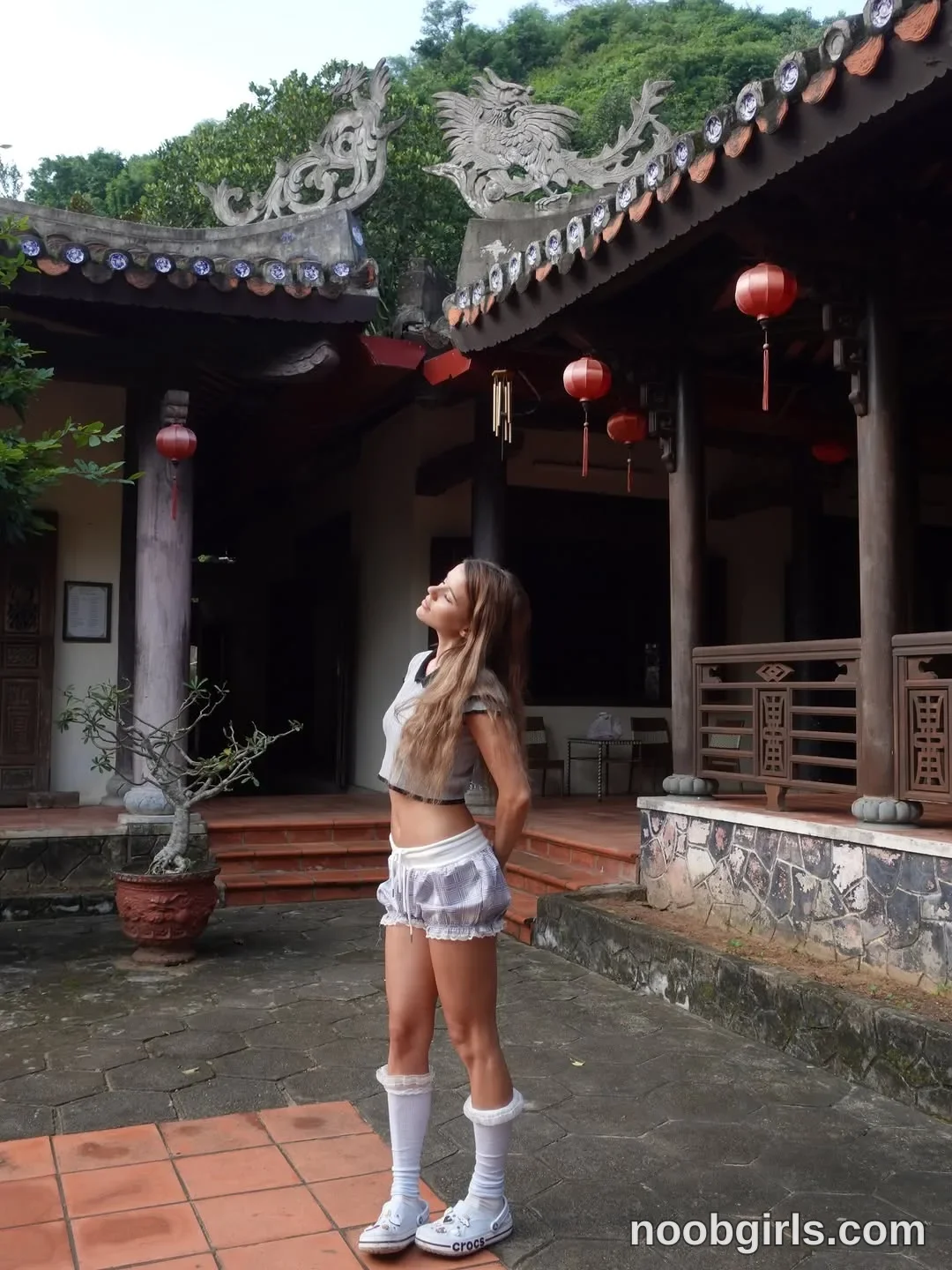waki_lucky Standing with her arms held behind her back wearing Light gray short-sleeved cropped top with dark trim