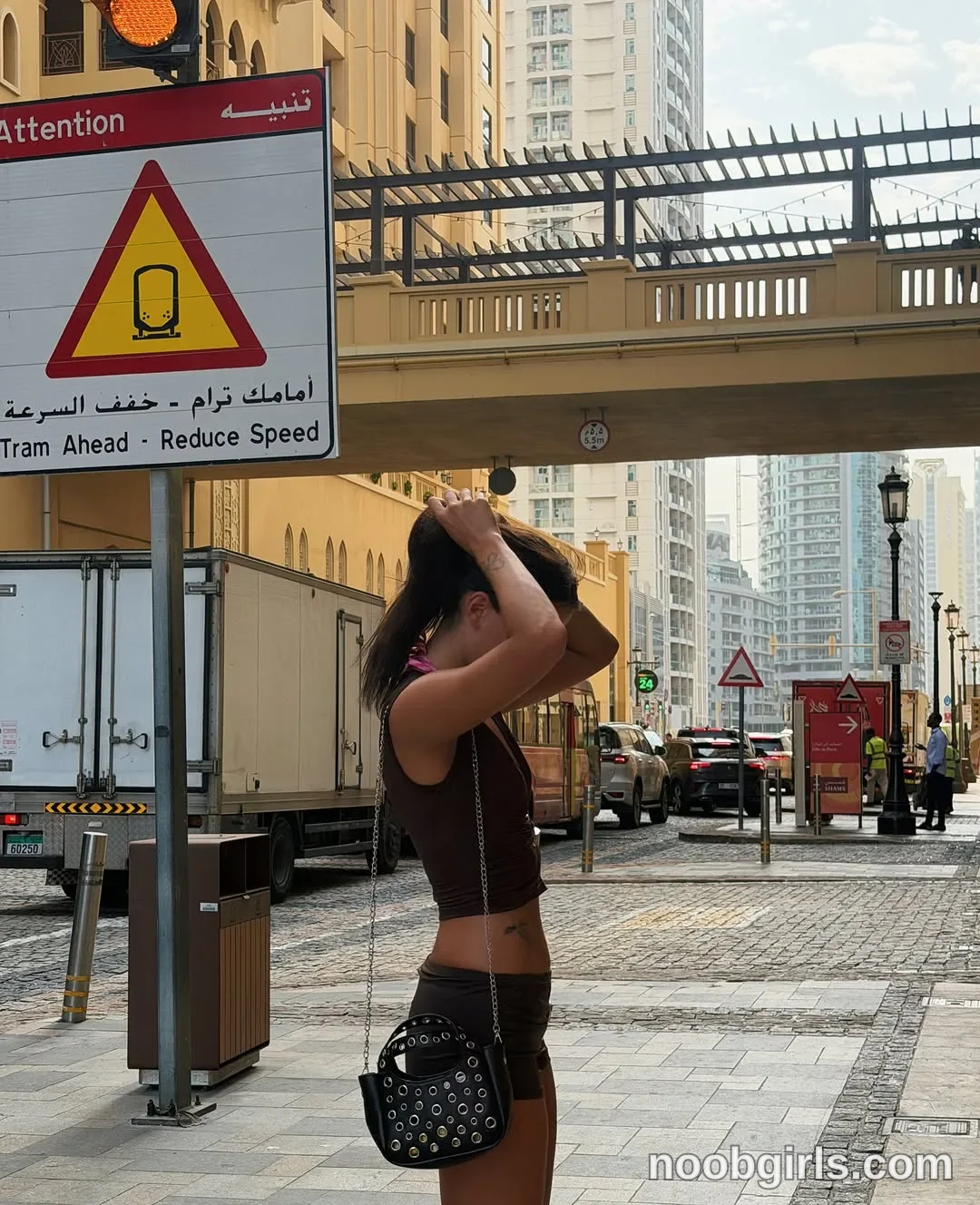 waki_lucky Standing in profile with both arms raised wearing Dark brown sleeveless cropped top