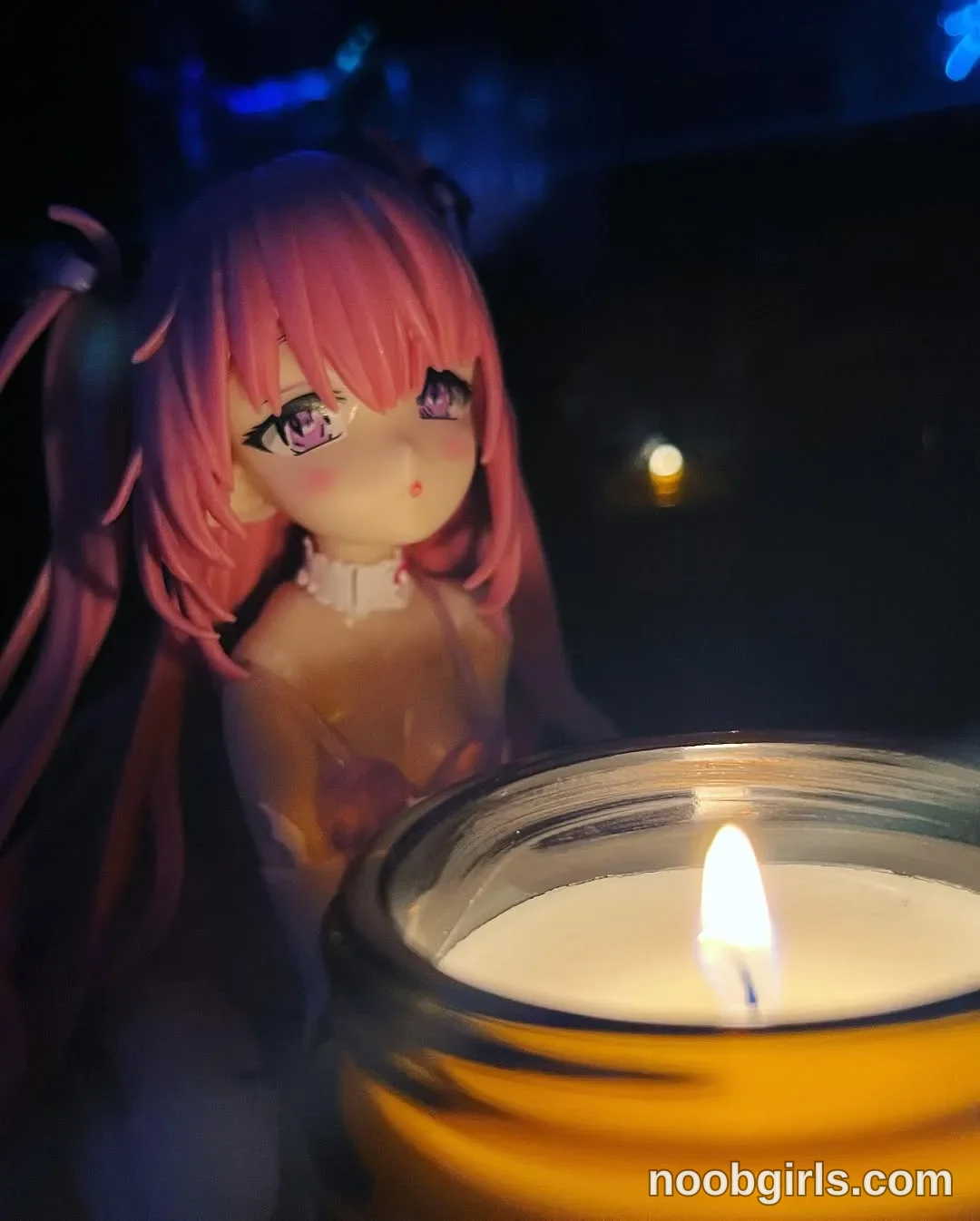 Lina anime-style figure is facing the camera wearing brownish-orange dress in dimly lit room