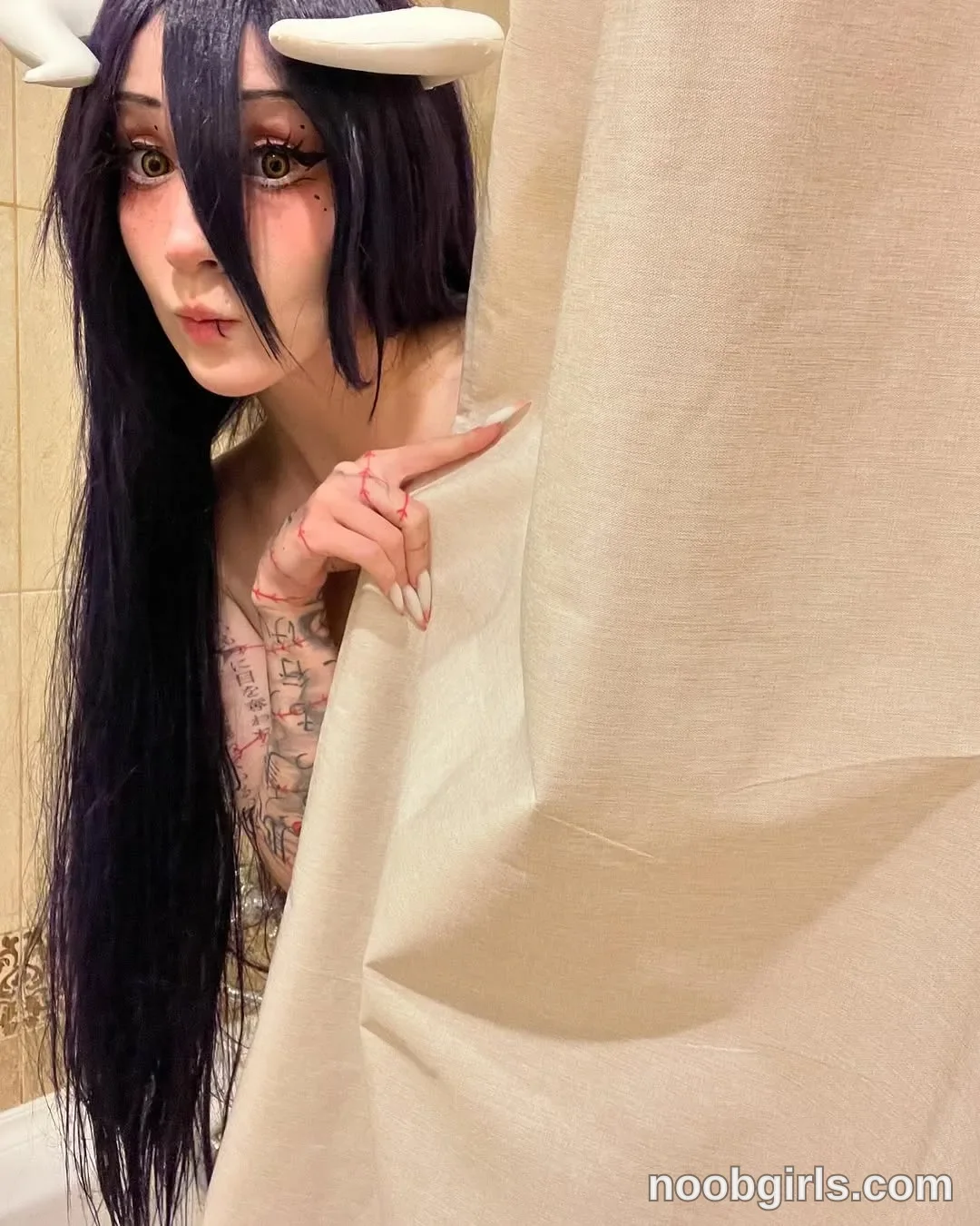 Lina Peeking from behind the curtain wearing long black wig in an interior room partly obscured by a curtain