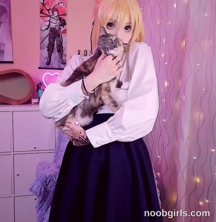 Lina holding a cat in her arms. wearing white long-sleeved blouse in bedroom or dressing room